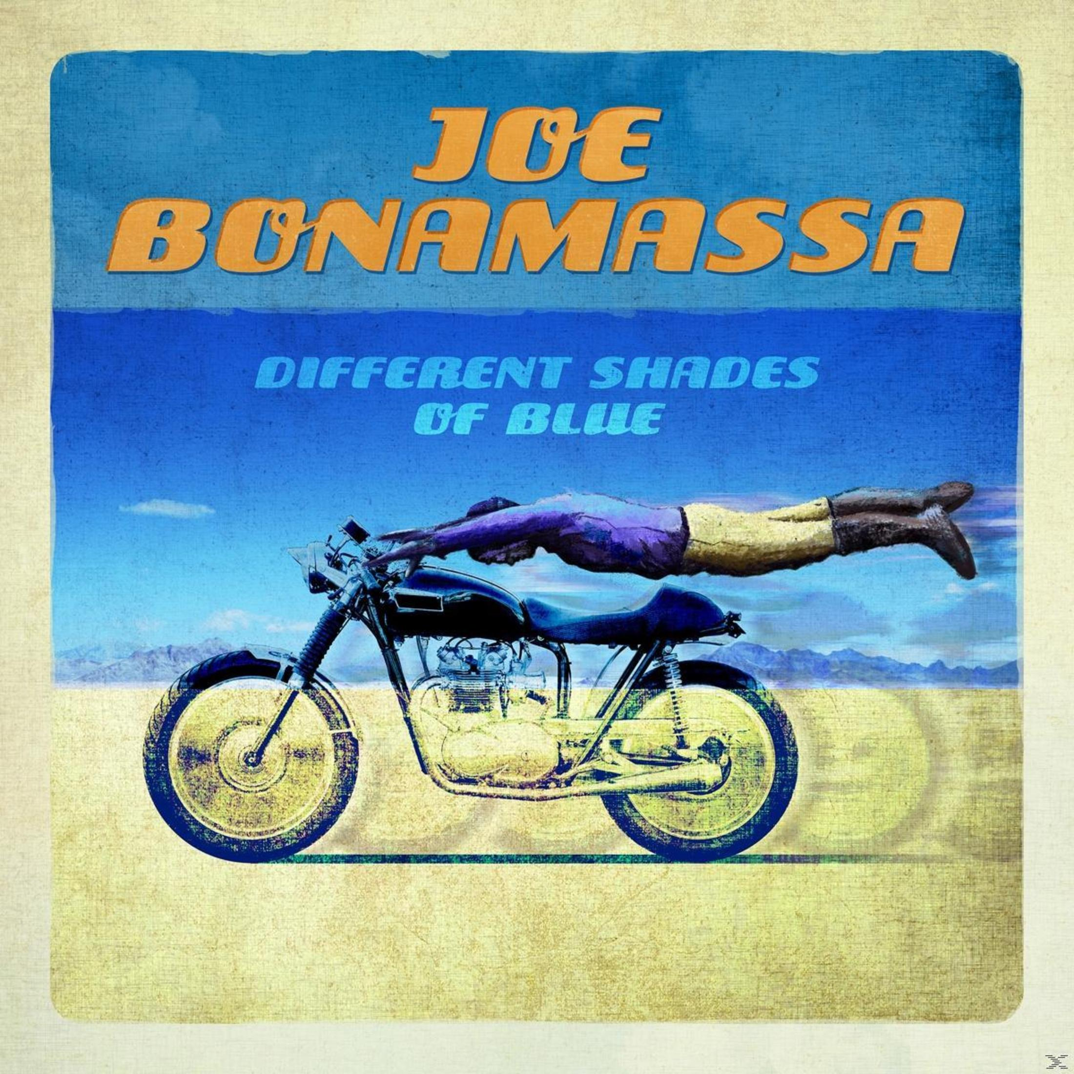 Ein Mann schwebt waagerecht über einem Motorrad in der Wüste. Text liest Joe Bonamassa.