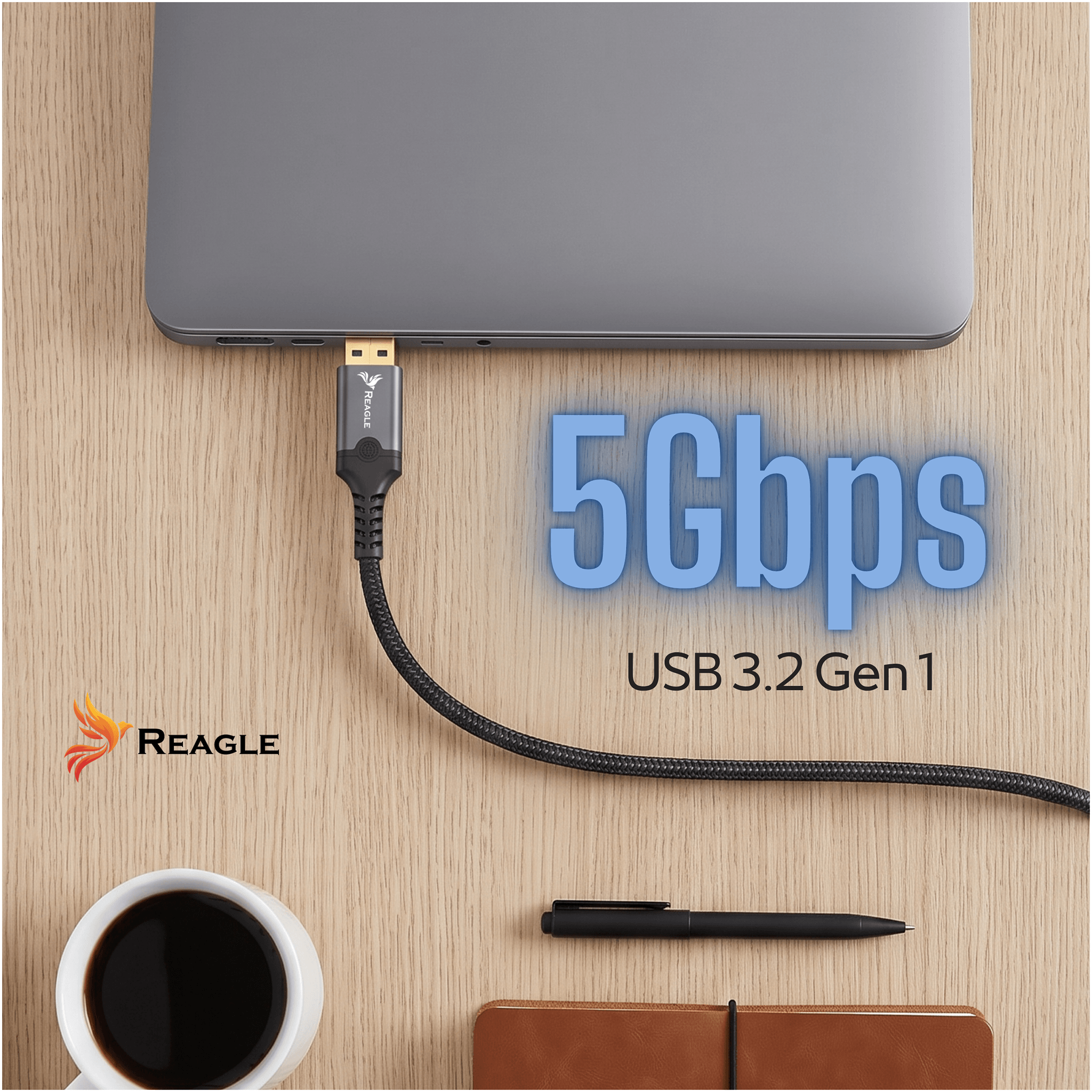 Un portátil gris en una mesa de madera con cable USB, taza de café, bolígrafo y cuaderno. Texto: 5Gbps USB 3.2 Gen 1.
