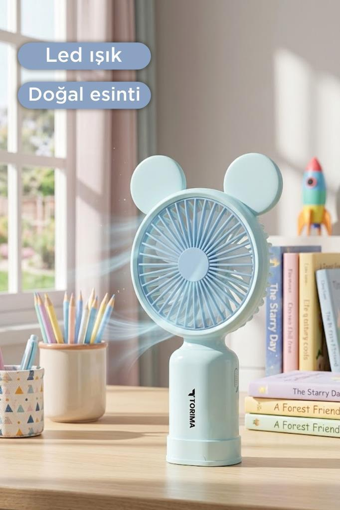 Yuvarlak kulaklı açık mavi masa vantilatörü, arkasında kalemler ve kitaplar olan ahşap masanın üzerinde.