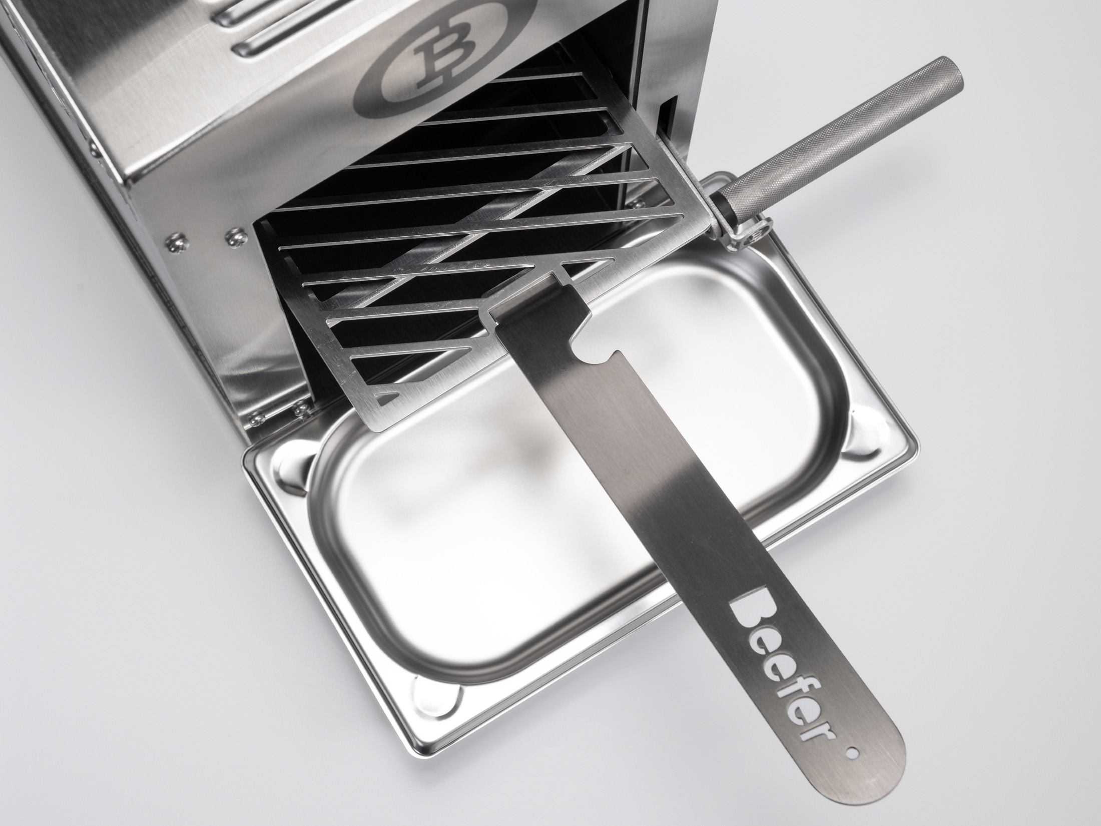 Edelstahl-BeefEater-Grill mit herausgezogenem Grillrost und Auffangschale auf hellem Grund.