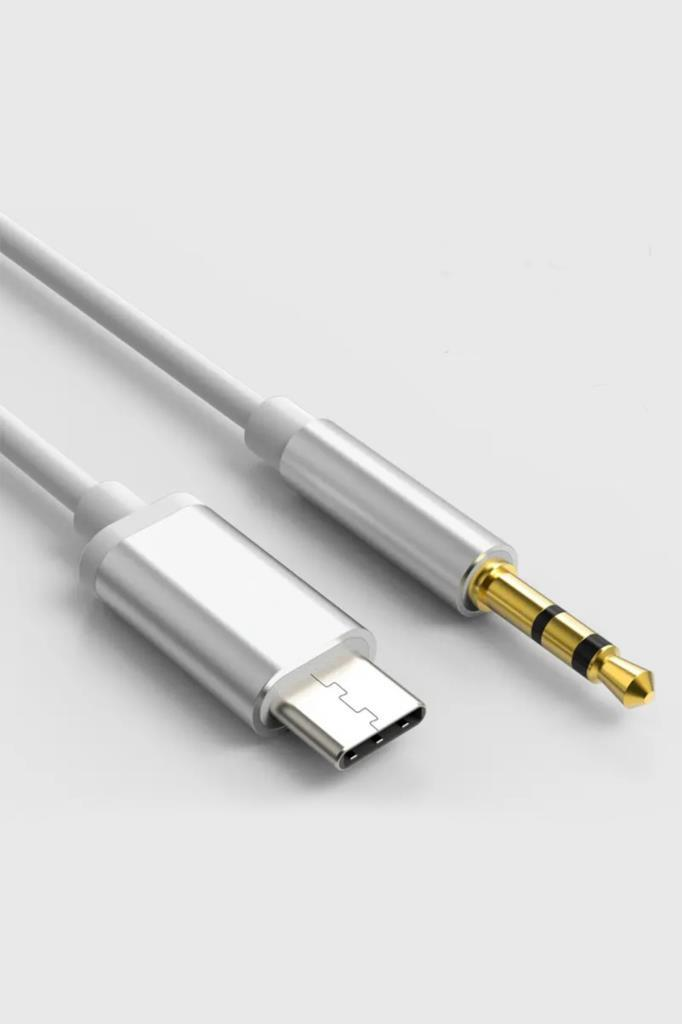 Açık renk arka planda gümüş renkli USB-C konnektörlü ve altın renkli 3.5 mm ses jaklı beyaz bir kablo.