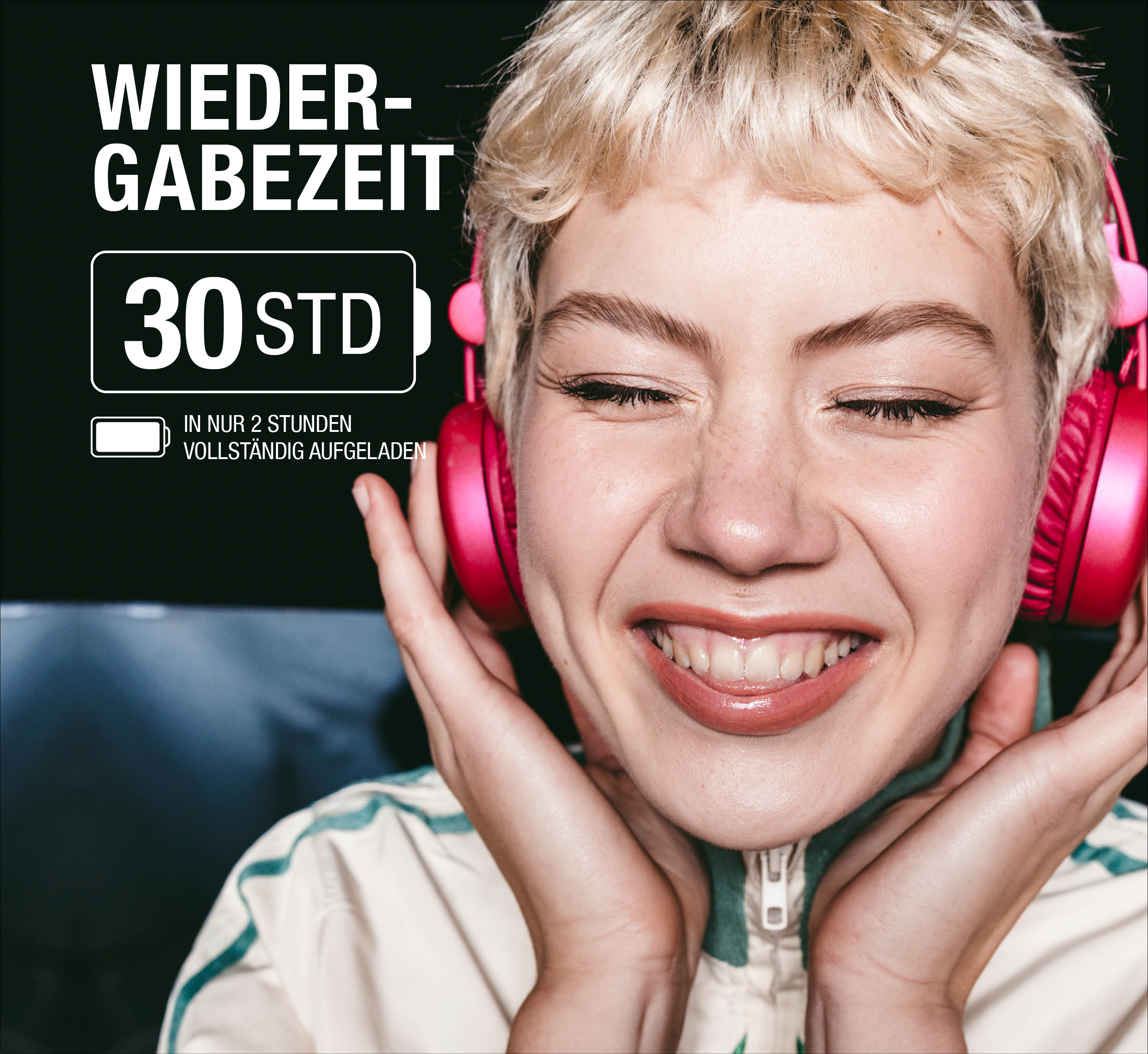Eine Frau mit kurzen blonden Haaren trägt pinke Kopfhörer und lächelt glücklich mit geschlossenen Augen.