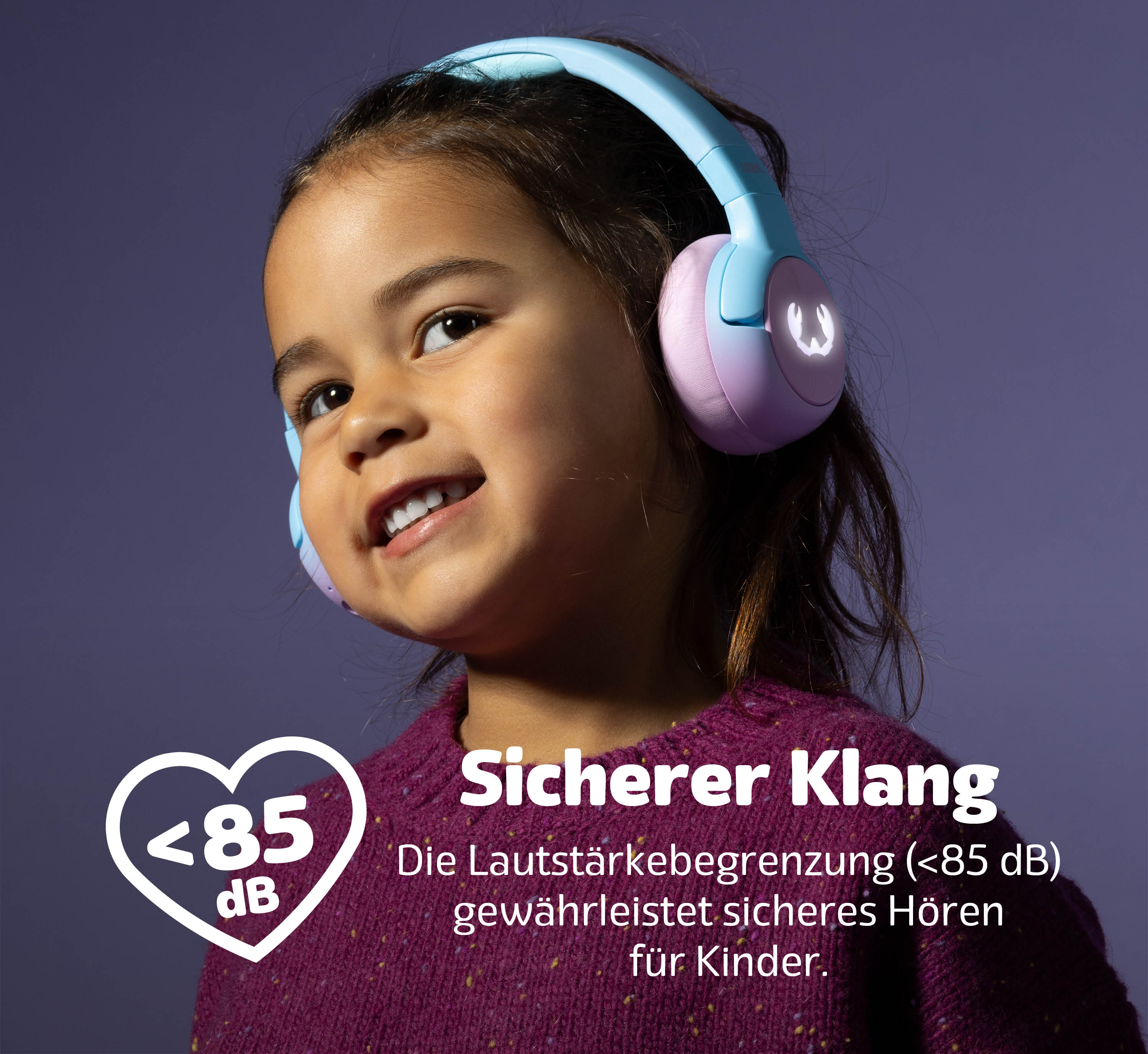 Ein Kind mit blauen und lila Kopfhörern lächelt. Text zeigt "Sicherer Klang" und "<lt/>85 dB".