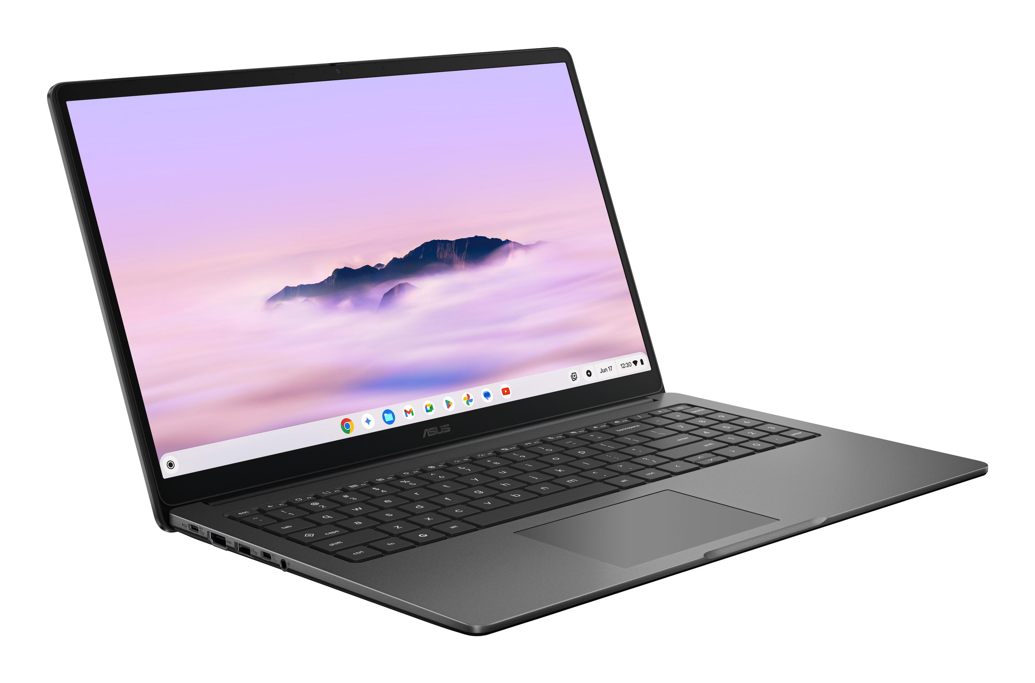 Ein grauer ASUS-Laptop steht auf einer weißen Oberfläche und zeigt ein Bergwallpaper.