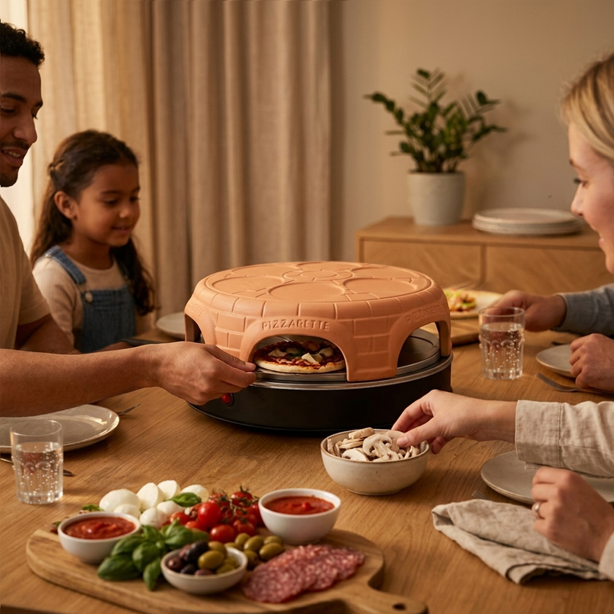Familia prepara mini pizzas en una mesa con ingredientes como mozzarella, tomates y salami en primer plano.