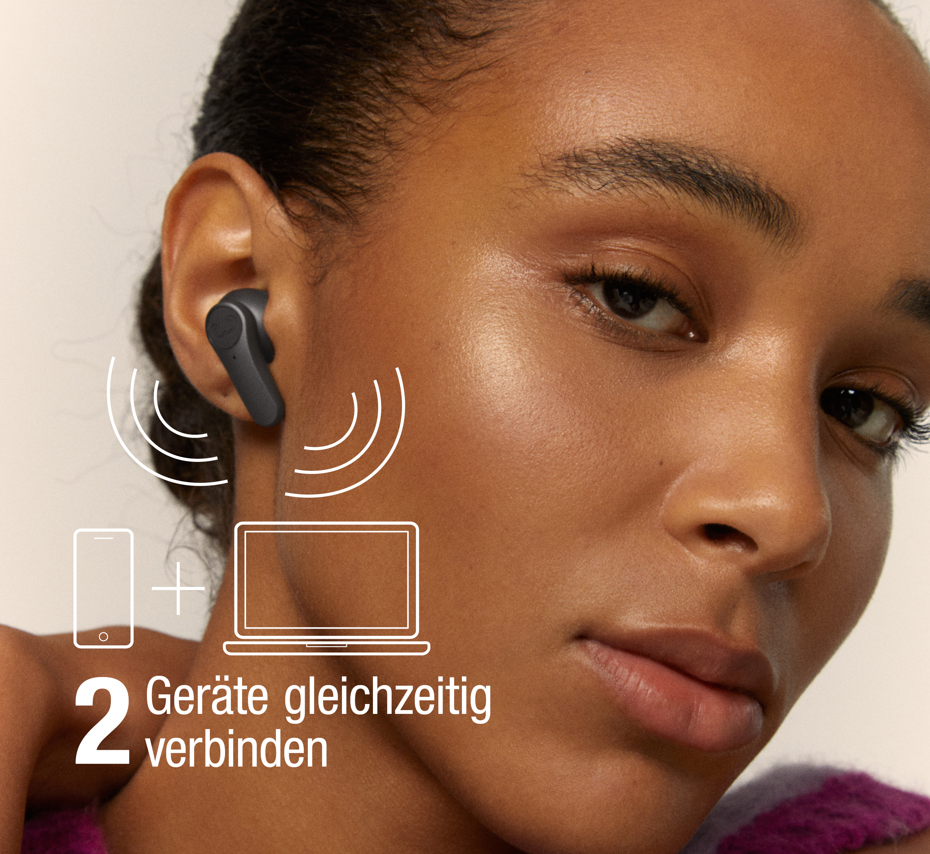 Eine Frau trägt einen schwarzen In-Ear-Kopfhörer. Symbole zeigen die Verbindung zu zwei Geräten gleichzeitig.