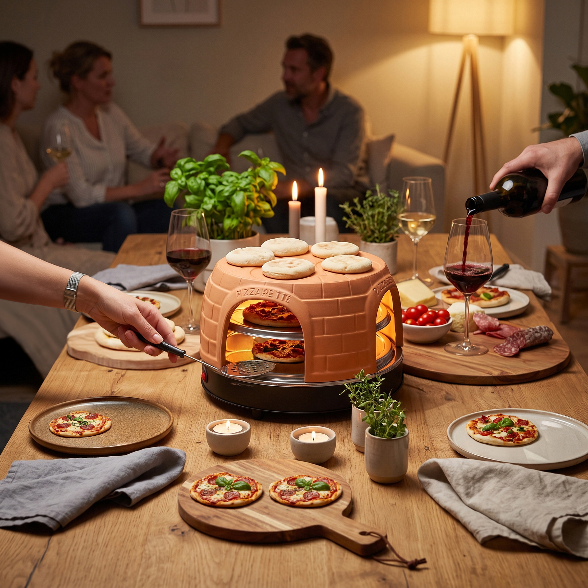 Freunde sitzen am Holztisch und genießen kleine Pizzen aus einem Tischofen, während Wein eingeschenkt wird.