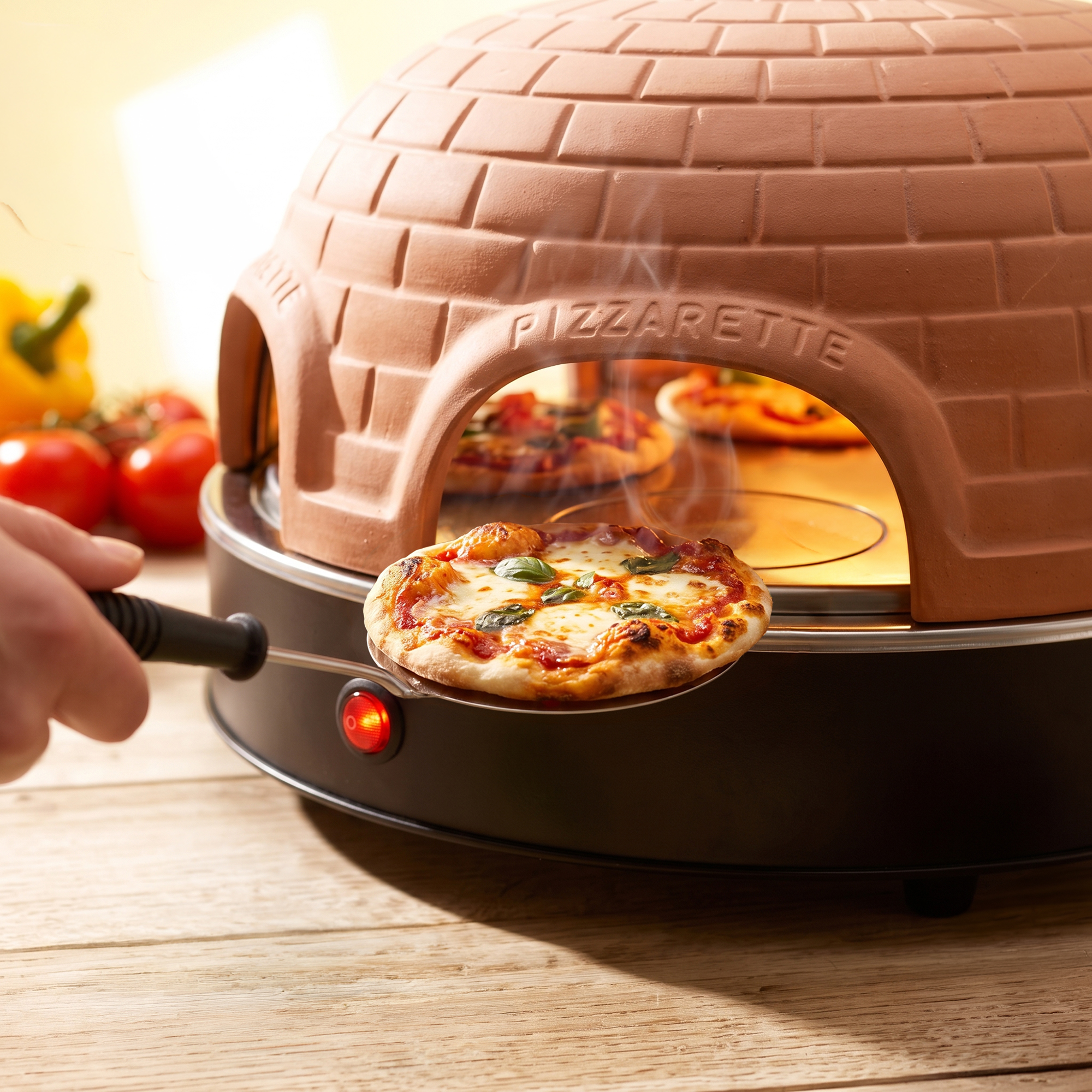 Eine kleine Pizza wird von einem Terrakotta-Pizzarette-Ofen auf einem Holztisch genommen.