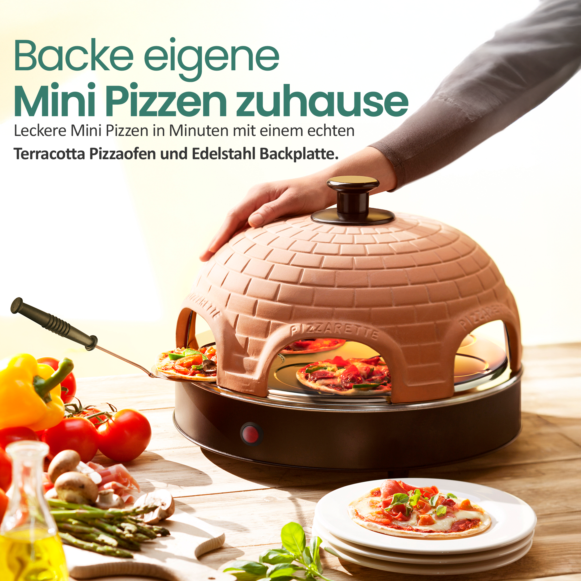 Person bedient einen Terracotta-Pizzaofen auf einem Holztisch mit Mini-Pizzen.