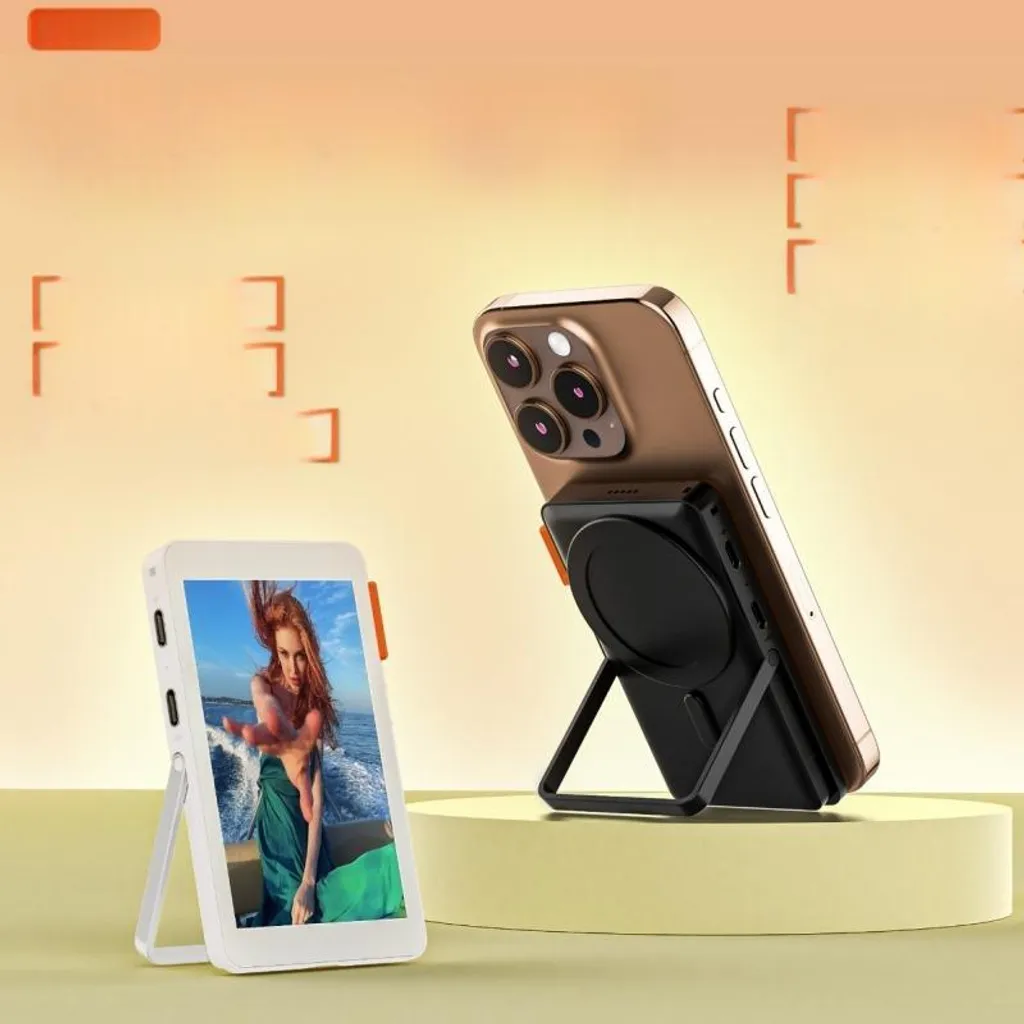Ein Smartphone auf einem schwarzen Magnethalter und ein weißer Fotorahmen auf einer gelben Fläche.