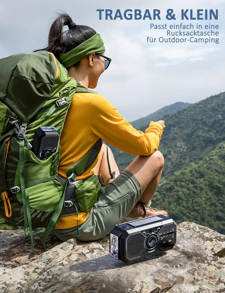 Wanderin sitzt auf Felsen mit großem grünem Rucksack und Notfallradio in malerischer Berglandschaft.