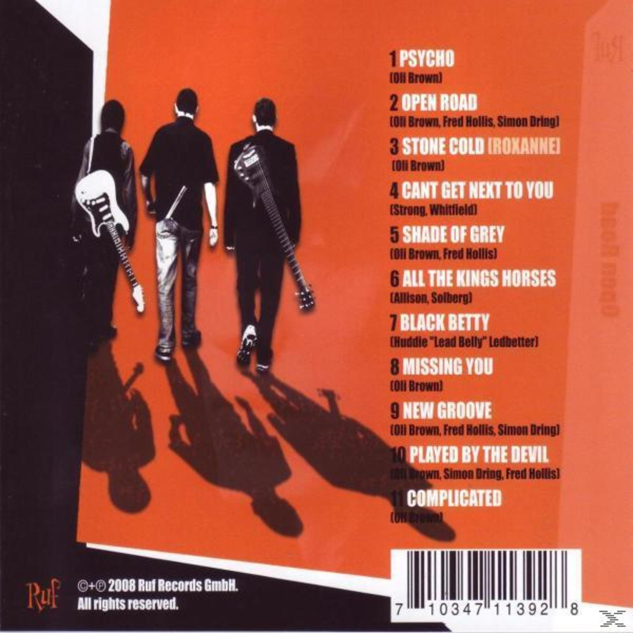 Rückseite einer Musik-CD zeigt drei Männer mit Gitarren und eine Trackliste vor rotem Hintergrund.