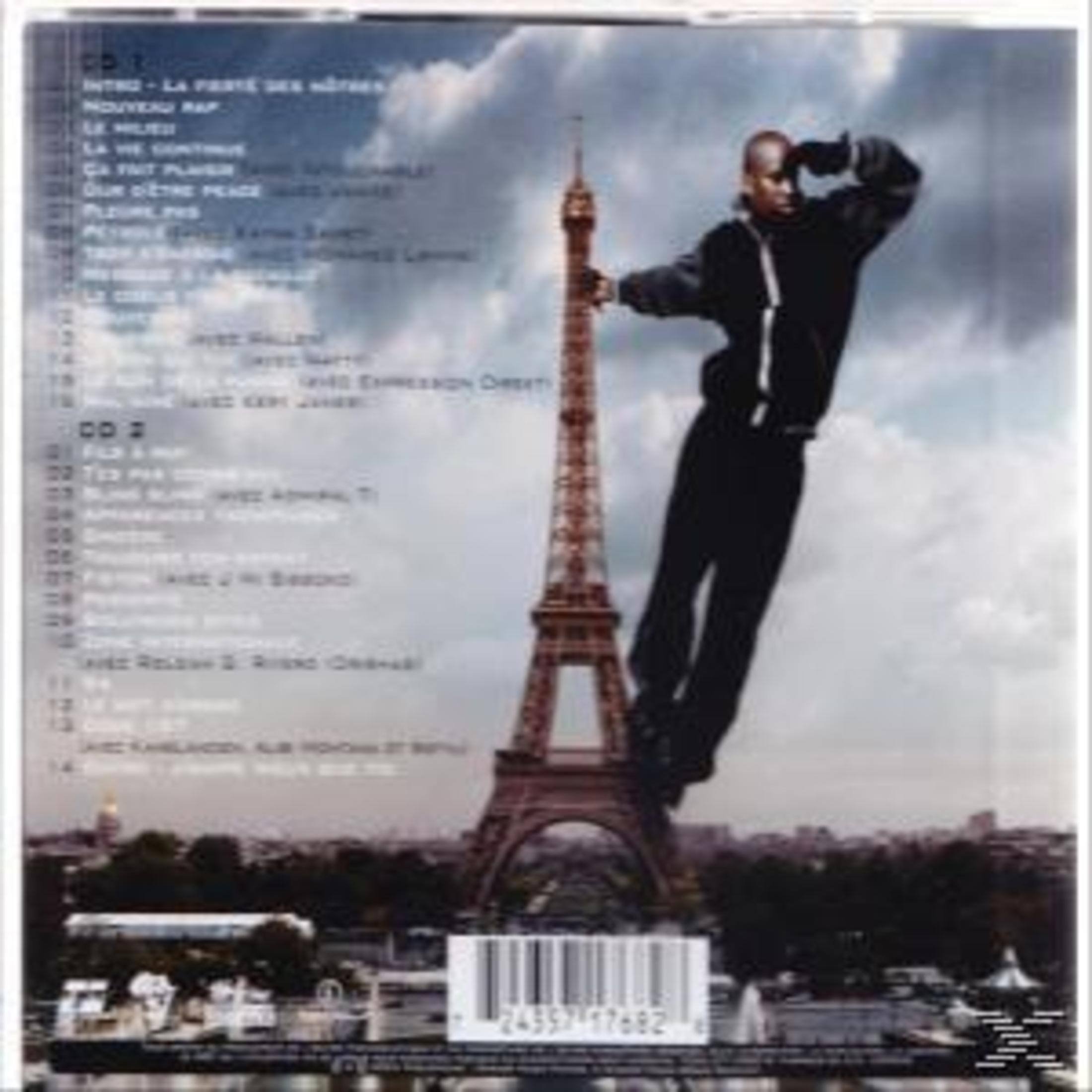 Ein Mann schwebt in der Luft neben dem Eiffelturm in Paris, im Hintergrund ist die Stadt zu sehen.