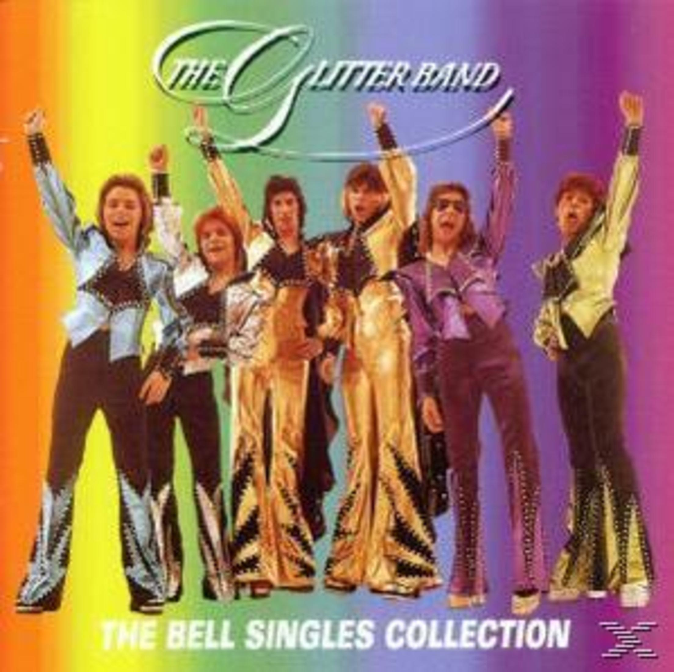 Die Mitglieder der Glitter Band posieren in bunten Bühnenoutfits vor einem bunten Regenbogenhintergrund.