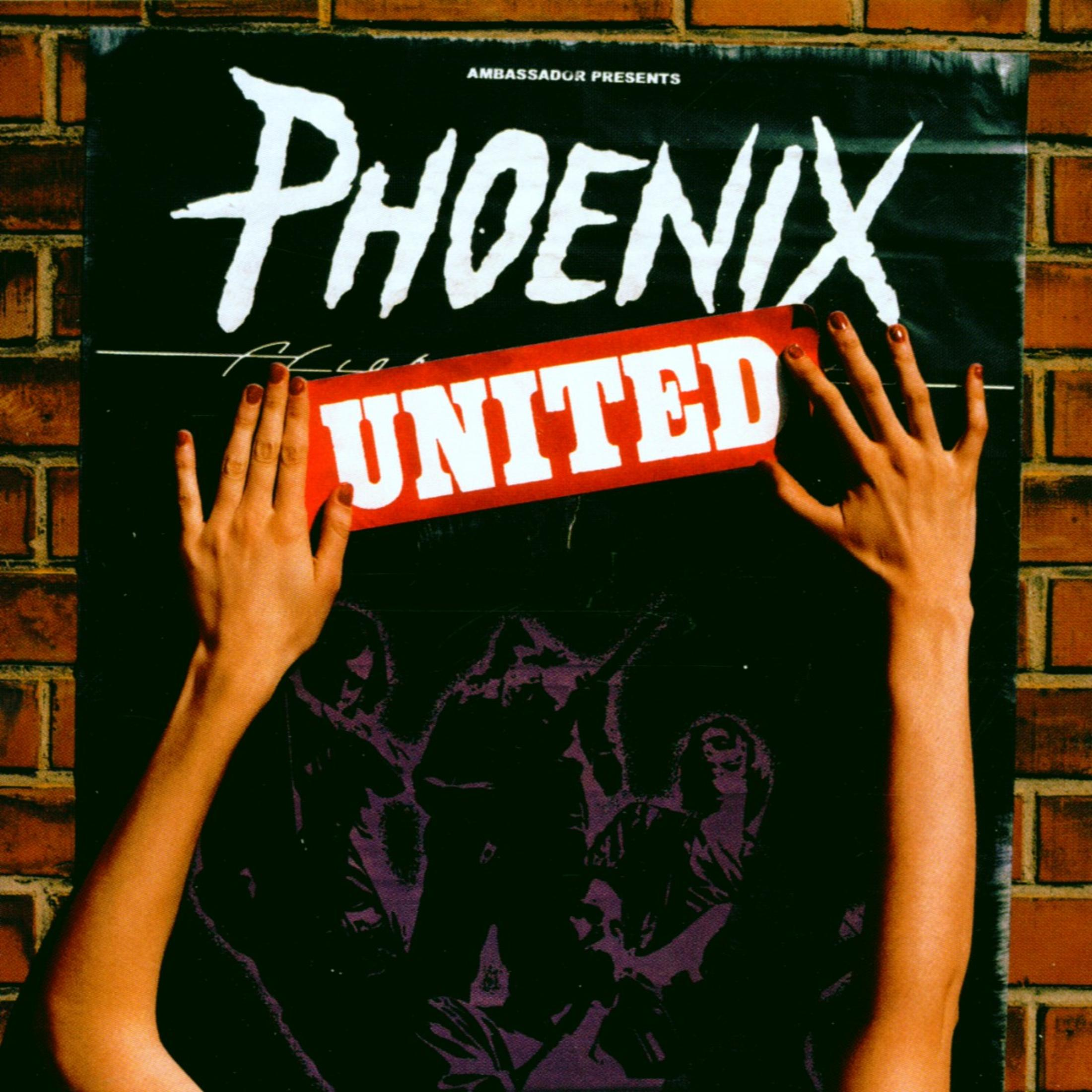 Hände kleben ein rotes UNITED-Schild auf ein schwarzes Phoenix-Plakat an einer Backsteinwand.