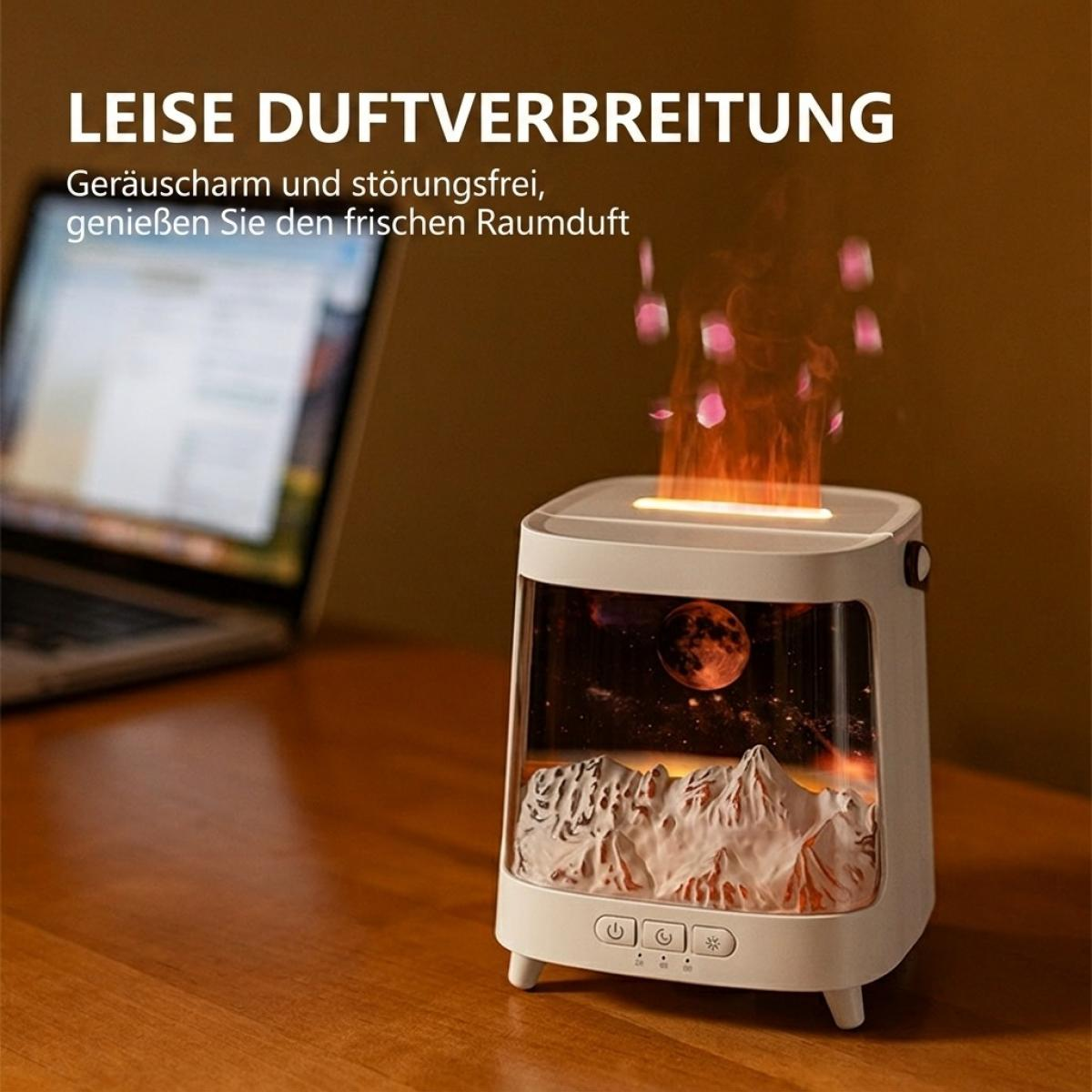 Ein weißer Aroma-Diffusor mit Bergszene und LED-Flammeneffekt steht auf einem Tisch vor einem Laptop.