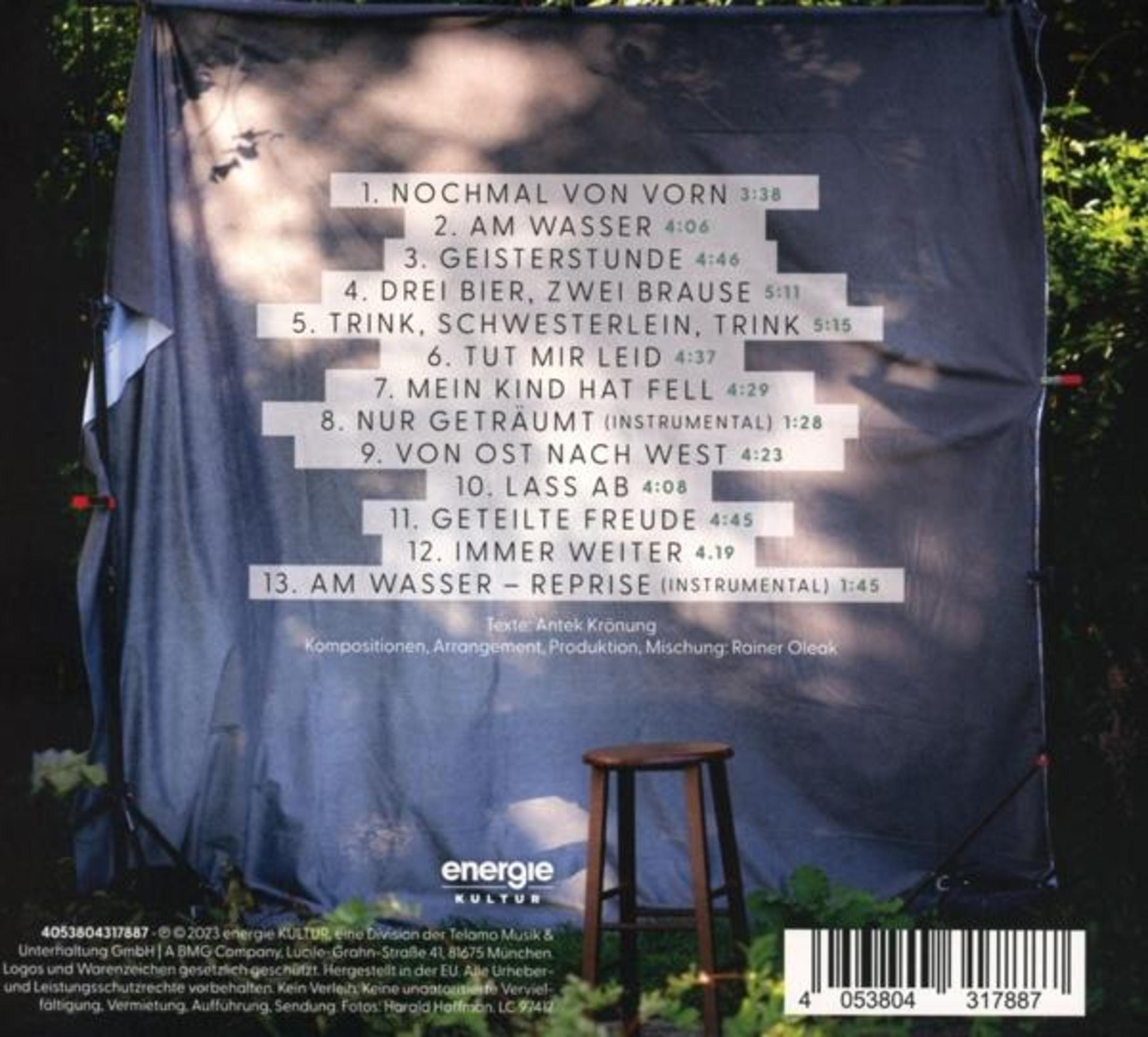 Rückseite einer Musik-CD mit Trackliste auf einem grauen Hintergrund und einem Holzhocker im Vordergrund.