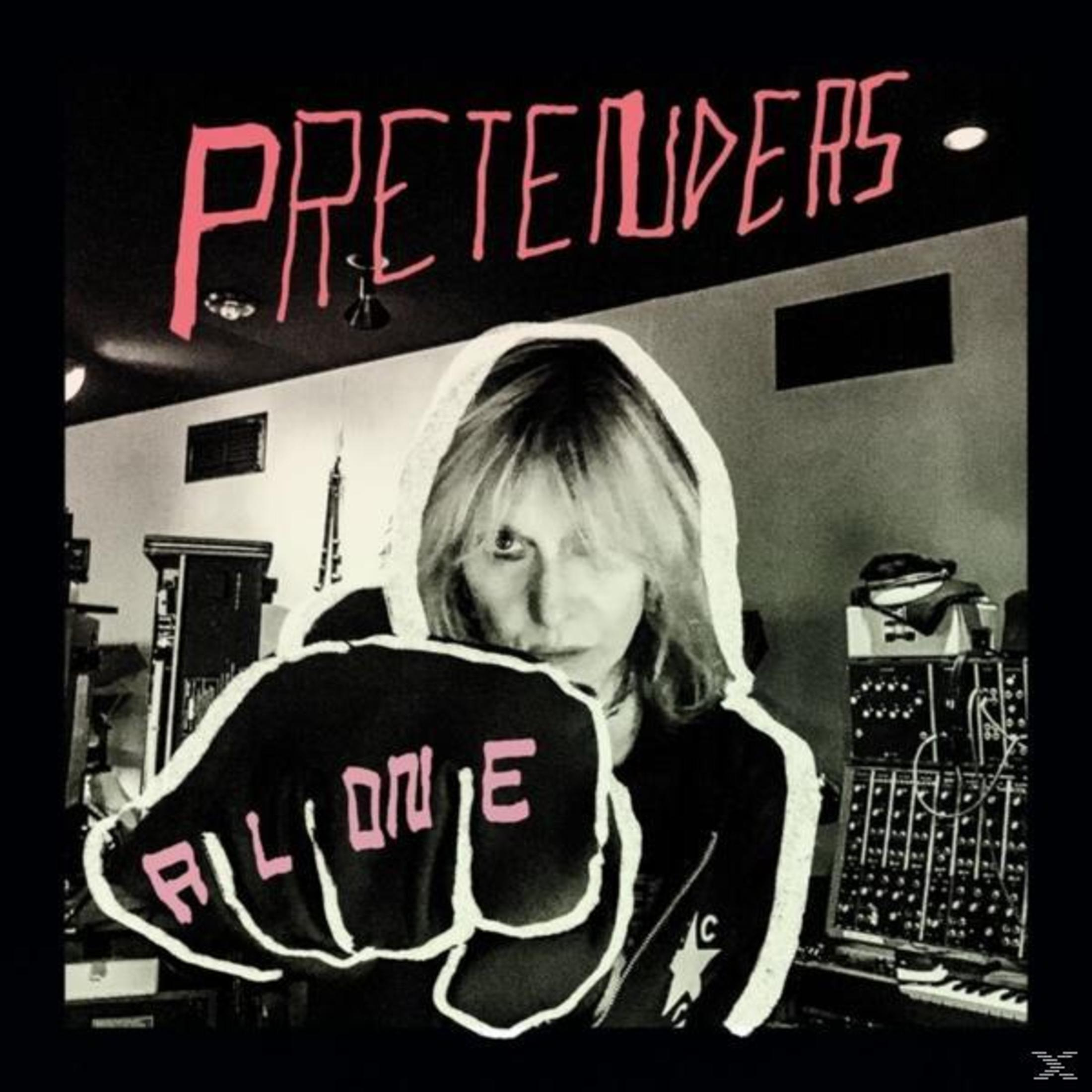Albumcover mit Chrissie Hynde in einer Kapuze, die die Faust mit der Aufschrift "Alone" in die Kamera hält.