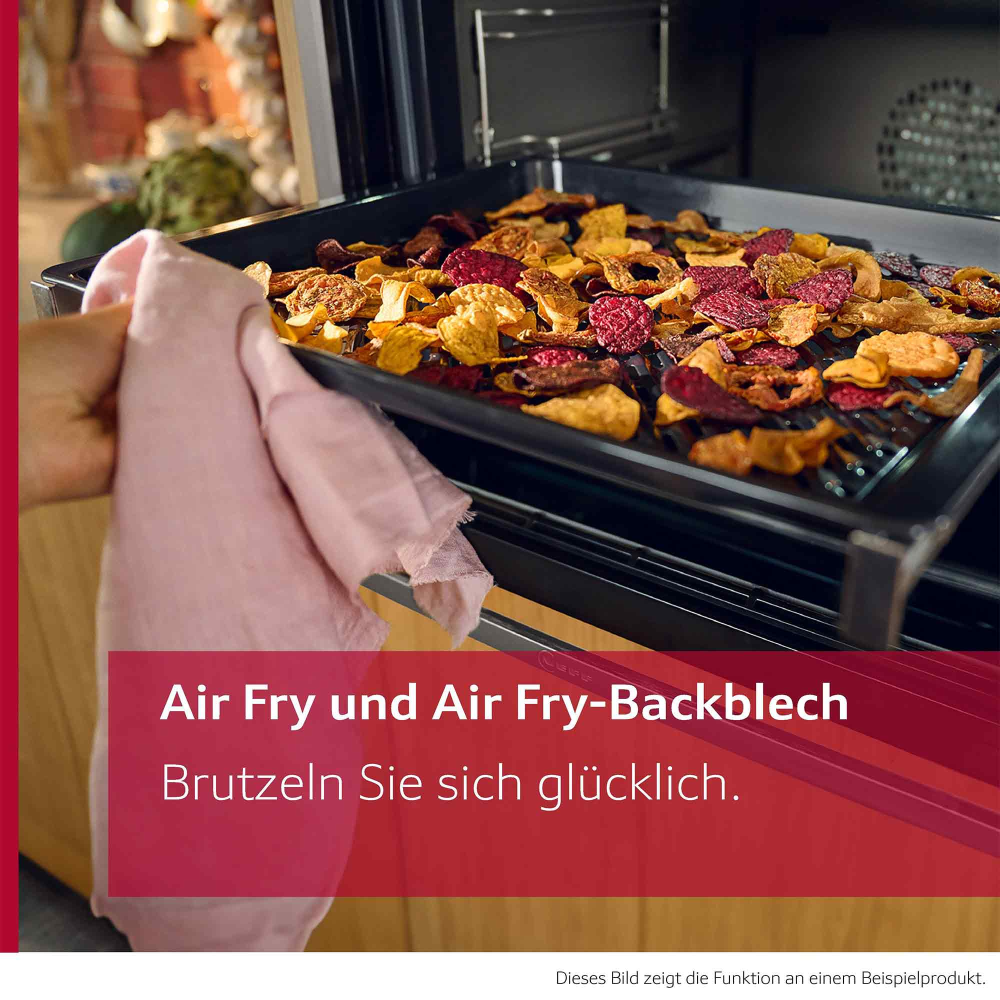 Ein Backblech mit bunten Gemüsepunkten wird aus einem Ofen gezogen.