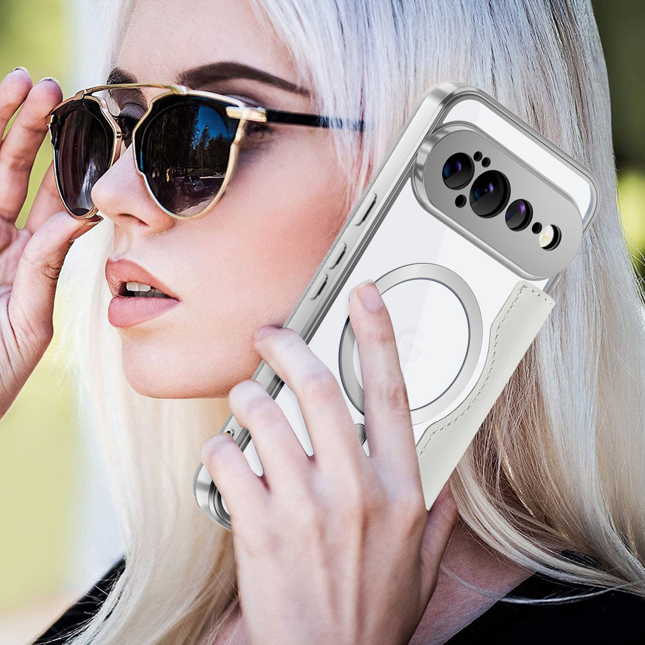 Eine blonde Frau mit Sonnenbrille hält ein weißes Handy mit silberner Hülle am Ohr.