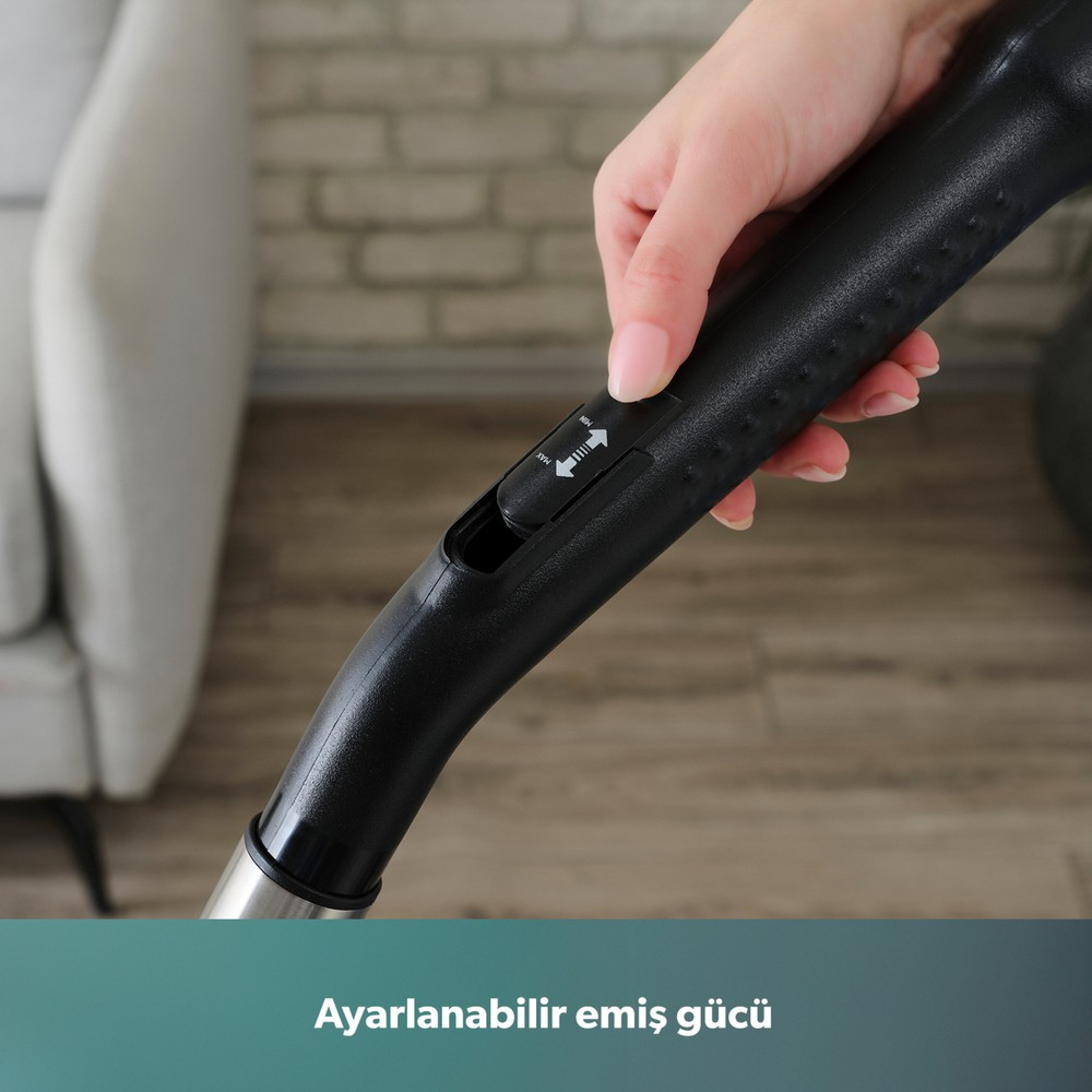 El, ayarlanabilir güç sürgüsüne sahip siyah süpürge sapını tutuyor.