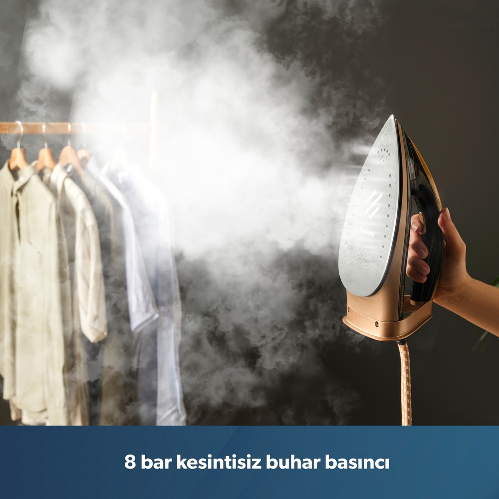 Bir el, askıdaki kıyafetlere yoğun buhar veren altın-siyah renkli bir buharlı ütü tutuyor.