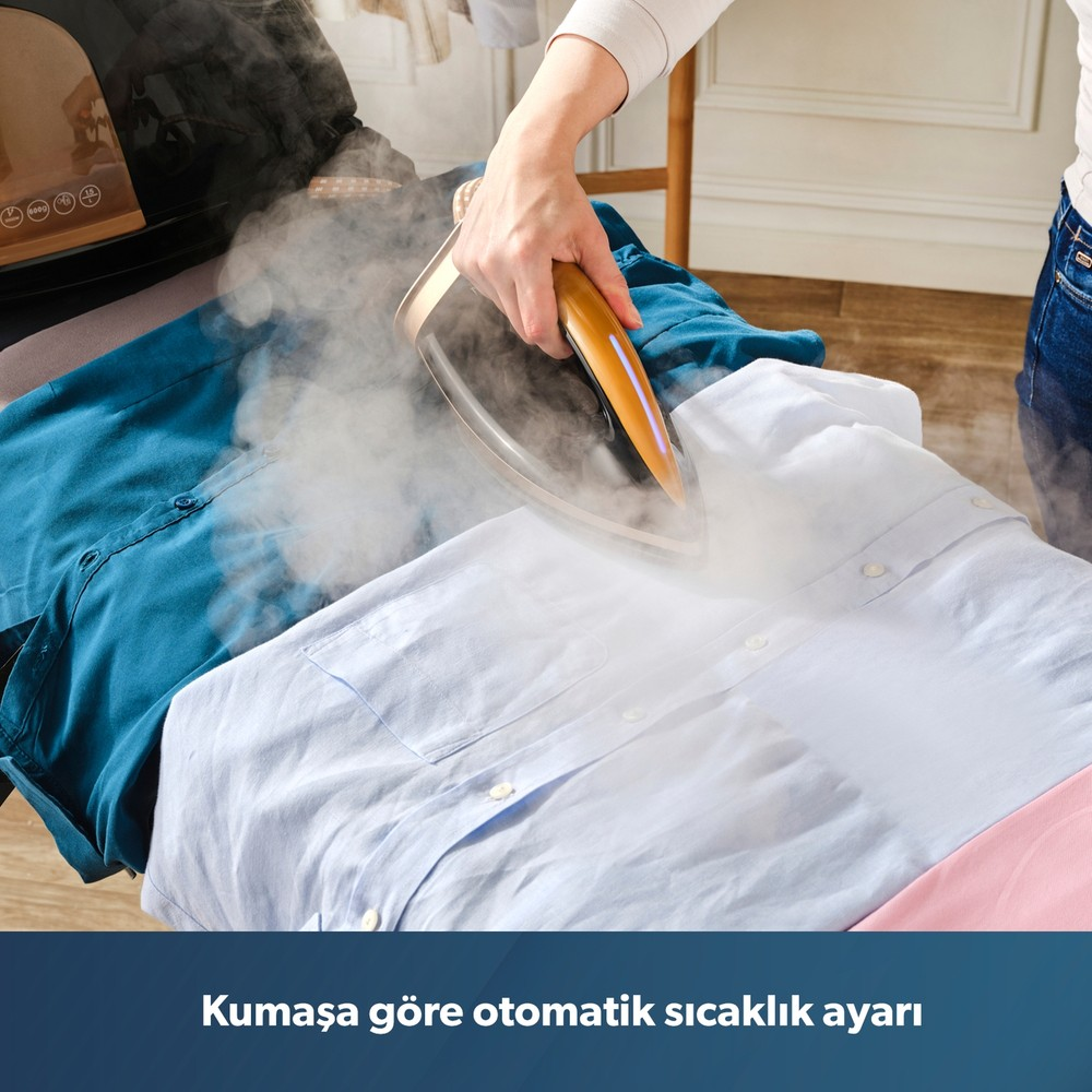 Bir kişi buharlı ütüyle mavi bir gömleği ütülüyor, etrafta buhar yükseliyor.