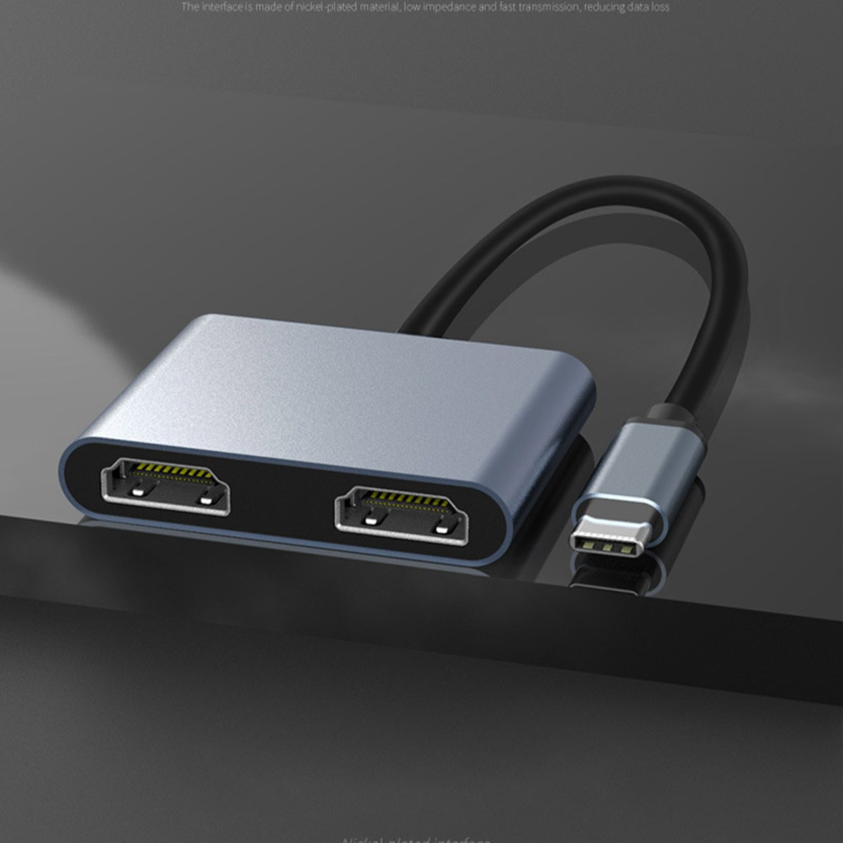 Srebrny hub USB-C z dwoma portami wyświetlania i podłączonym kablem Type-C na ciemnym tle.