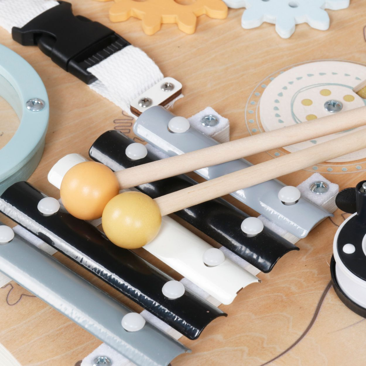 Ein hölzernes Busy Board mit Xylophon, Schlägeln, Schnallen und Zahnrädern für Kinder.