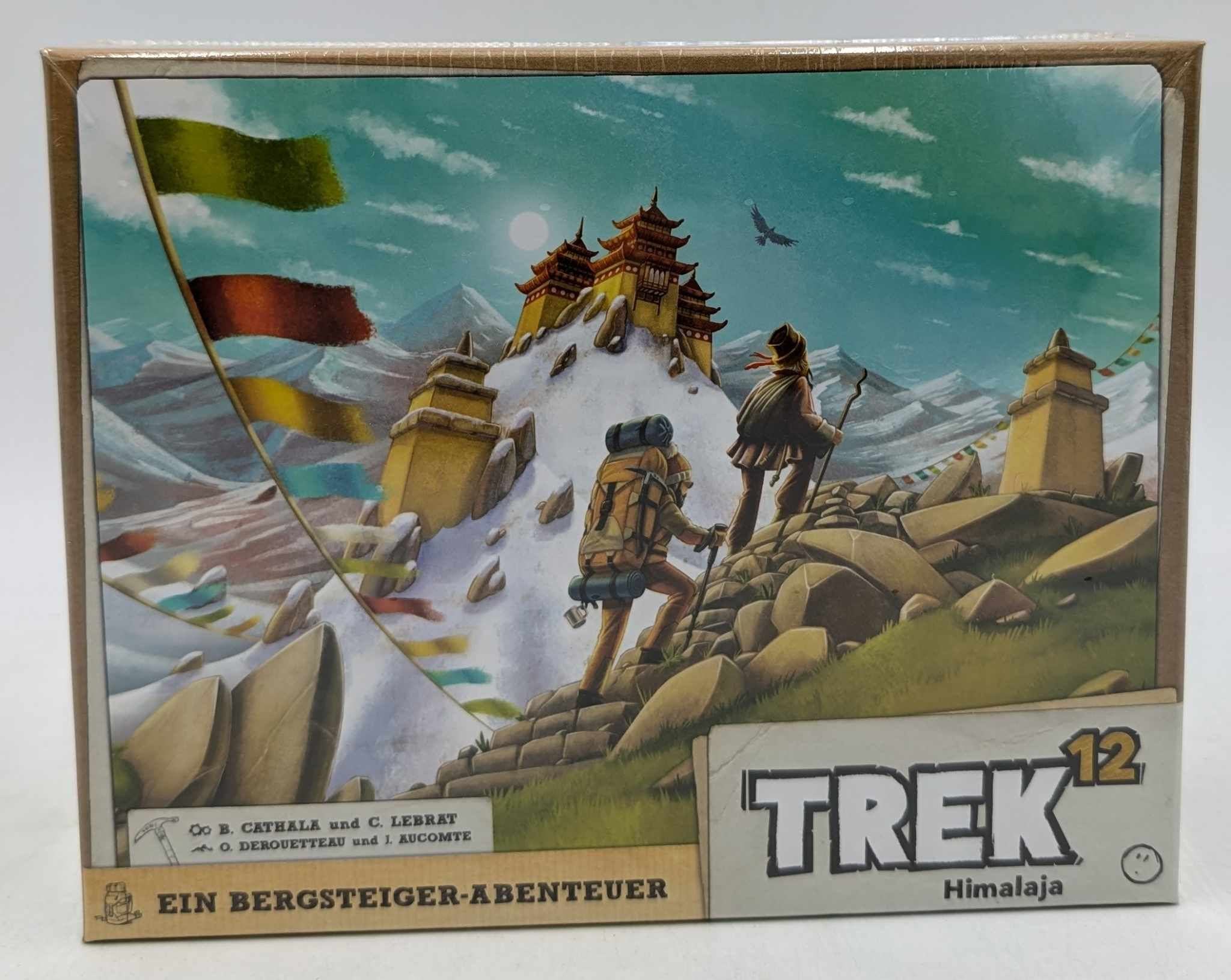 Deux randonneurs gravissent un pic himalayen enneigé vers une pagode au sommet avec des drapeaux de prière.