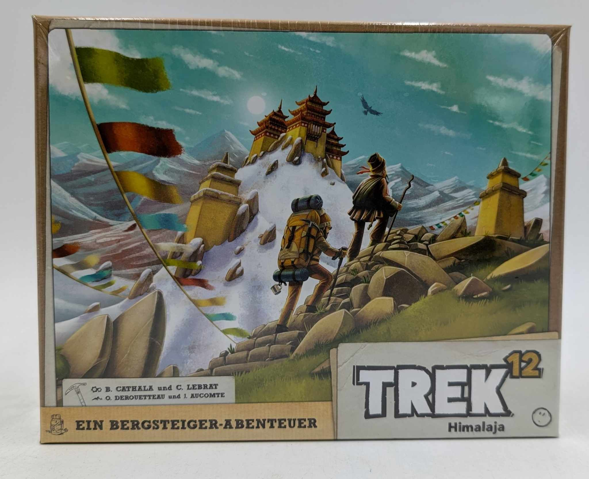 Boîte de jeu Trek 12 Himalaya montrant deux randonneurs gravissant une montagne enneigée vers un temple avec des fanions.
