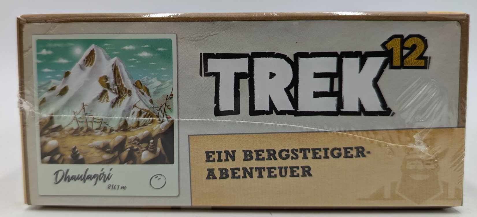 Emballage du jeu de société Trek 12 avec image de montagne et texte Une Aventure d'Alpiniste.