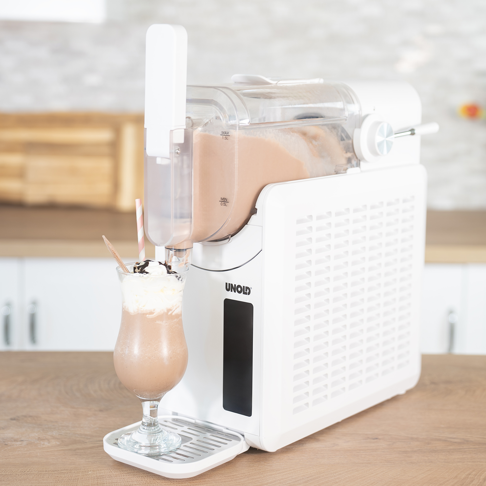 Eine weiße Eismaschine auf einer Holzarbeitsplatte füllt einen Milchshake mit Schlagsahne in ein Glas ab.