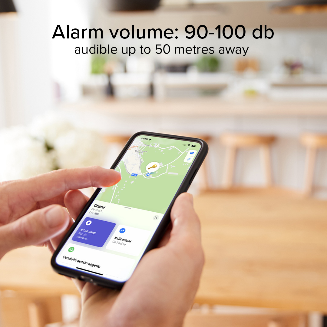 Una persona sostiene un smartphone con una app de mapas y un icono de llave, texto sobre el volumen de alarma.
