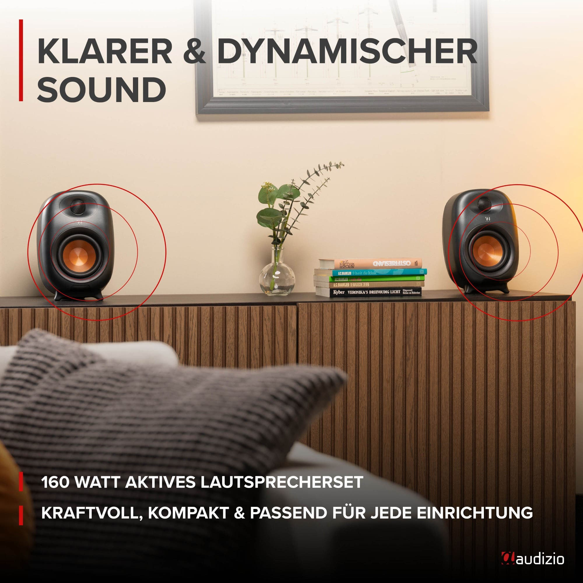 Zwei schwarze Lautsprecher auf einem Holzsideboard mit rotem Soundwellen-Grafikdesign und Text.
