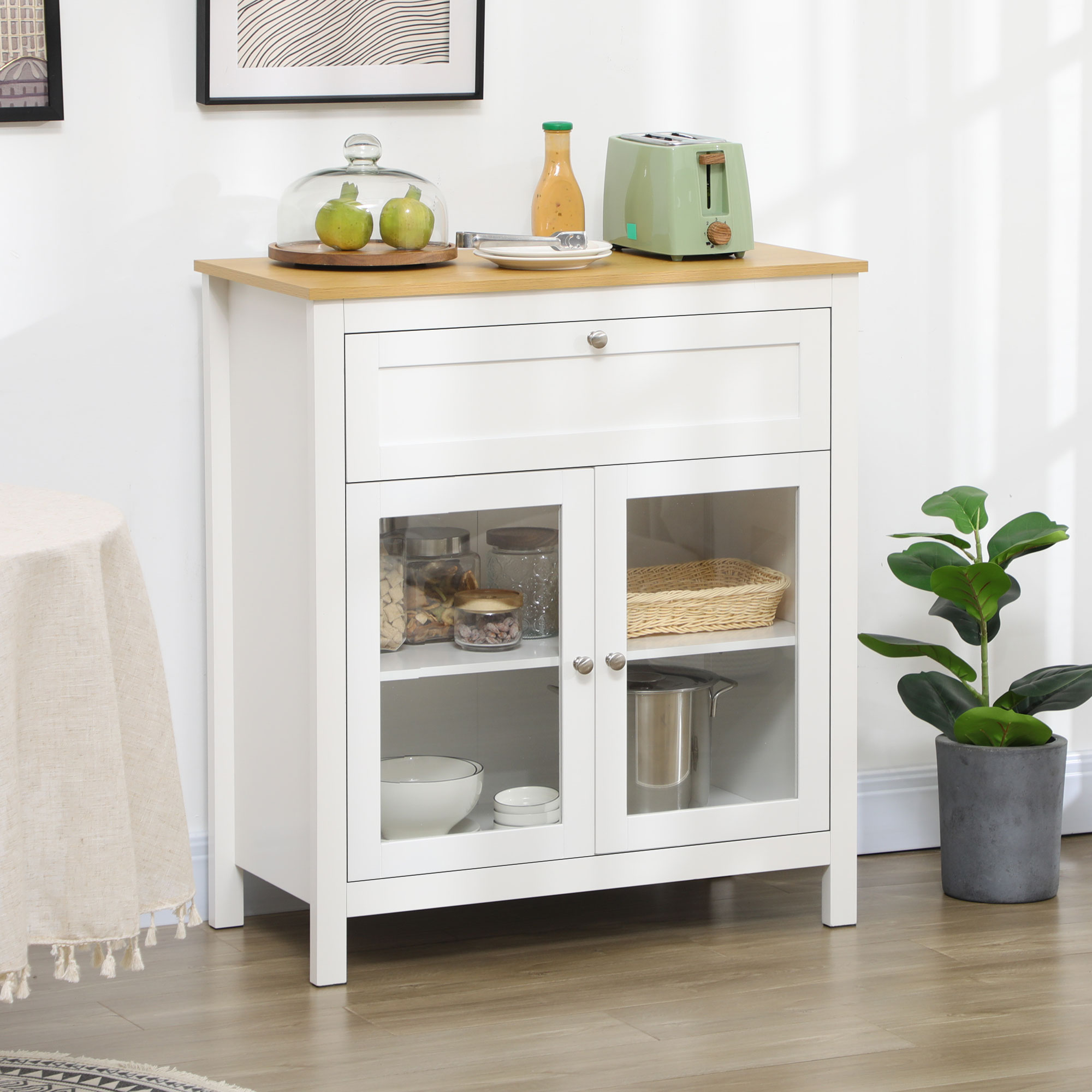 Un mueble de cocina blanco con puertas de cristal y encimera de madera junto a una planta en maceta.