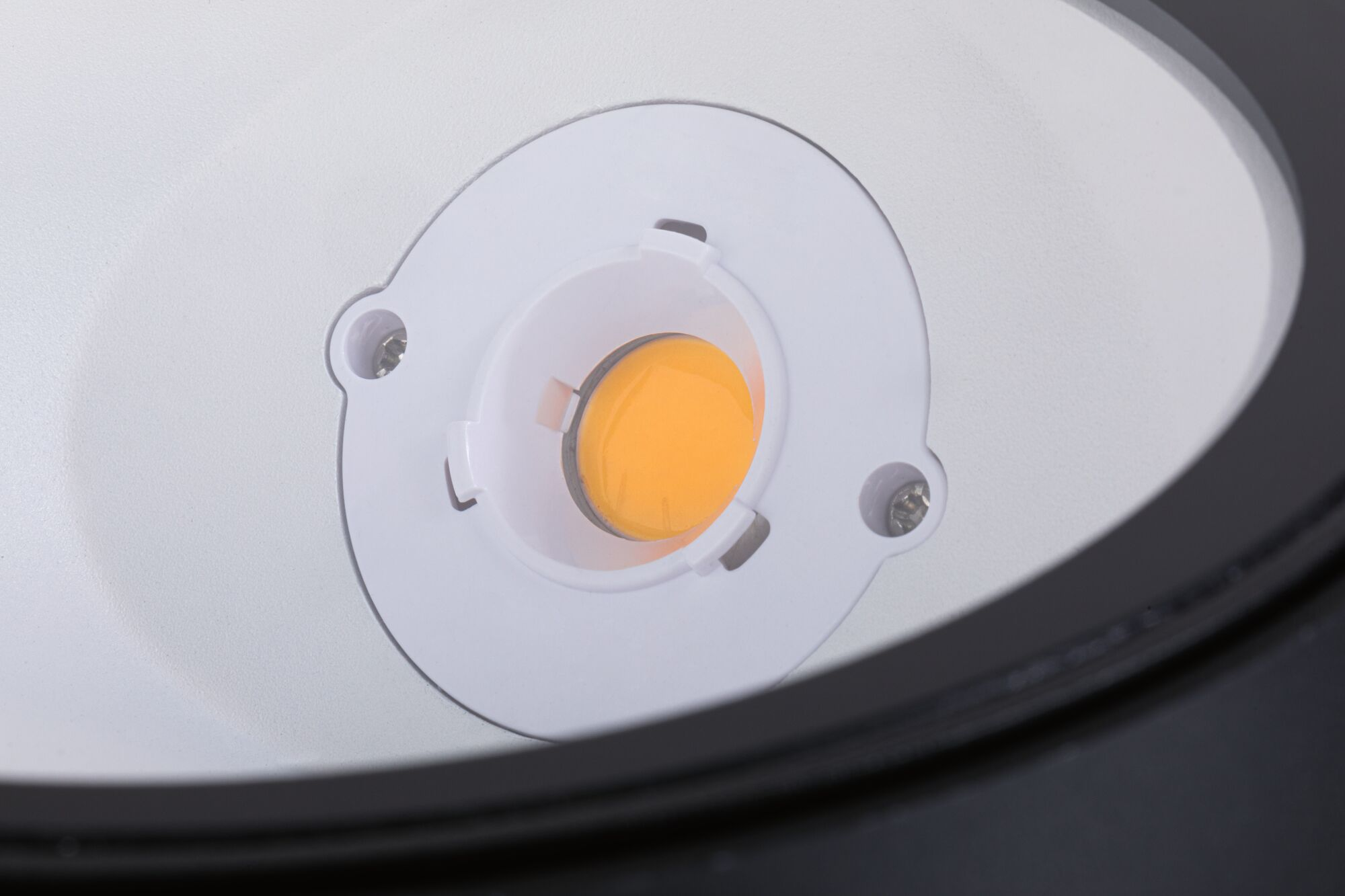 Nahaufnahme einer runden COB-LED mit gelbem Chip auf weißem Sockel.