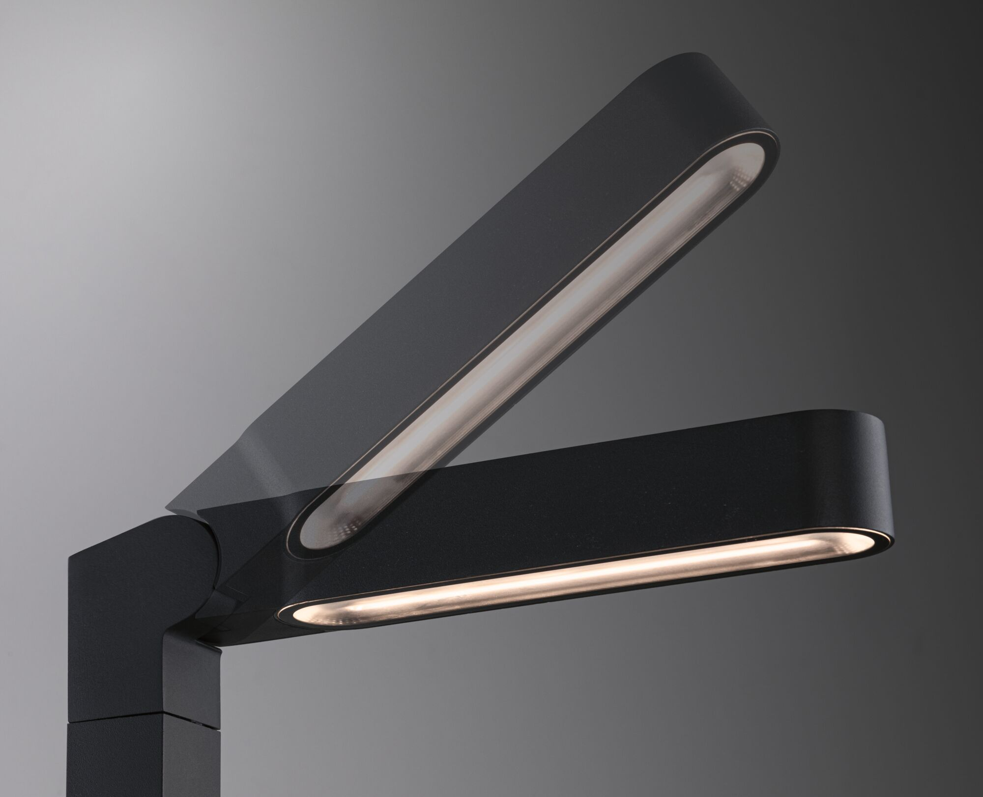 Schwarze moderne Tischlampe mit verstellbarem Kopf auf grauem Hintergrund.