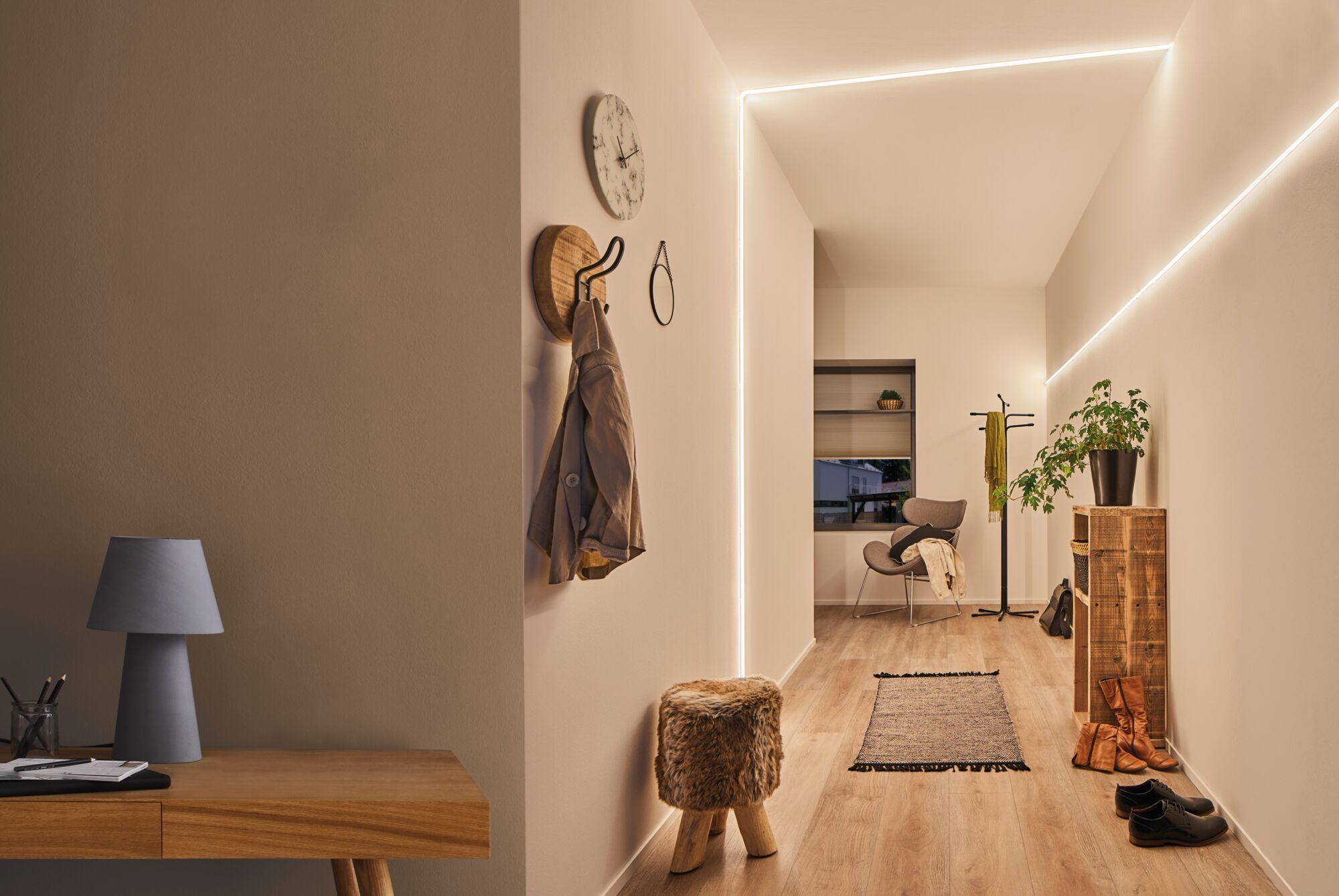 Moderne Flurbeleuchtung mit LED-Streifen, Holzmöbeln, Uhr und Hocker auf Holzboden.