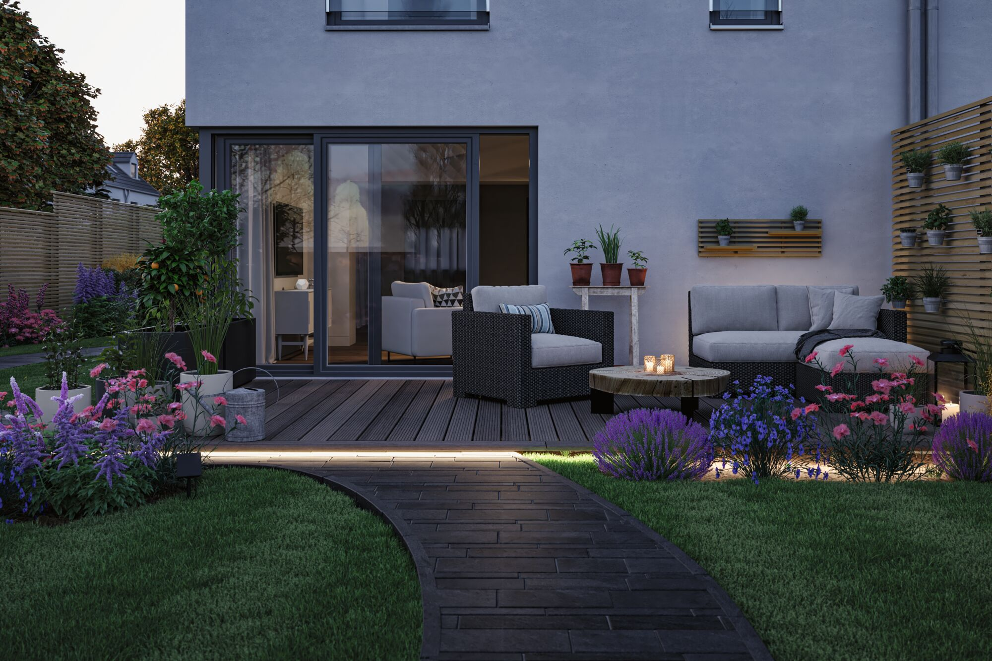 Beleuchtete Holzterrasse mit gemütlichen Möbeln, Pflanzen und einem geschwungenen Steinweg im Garten bei Dämmerung.