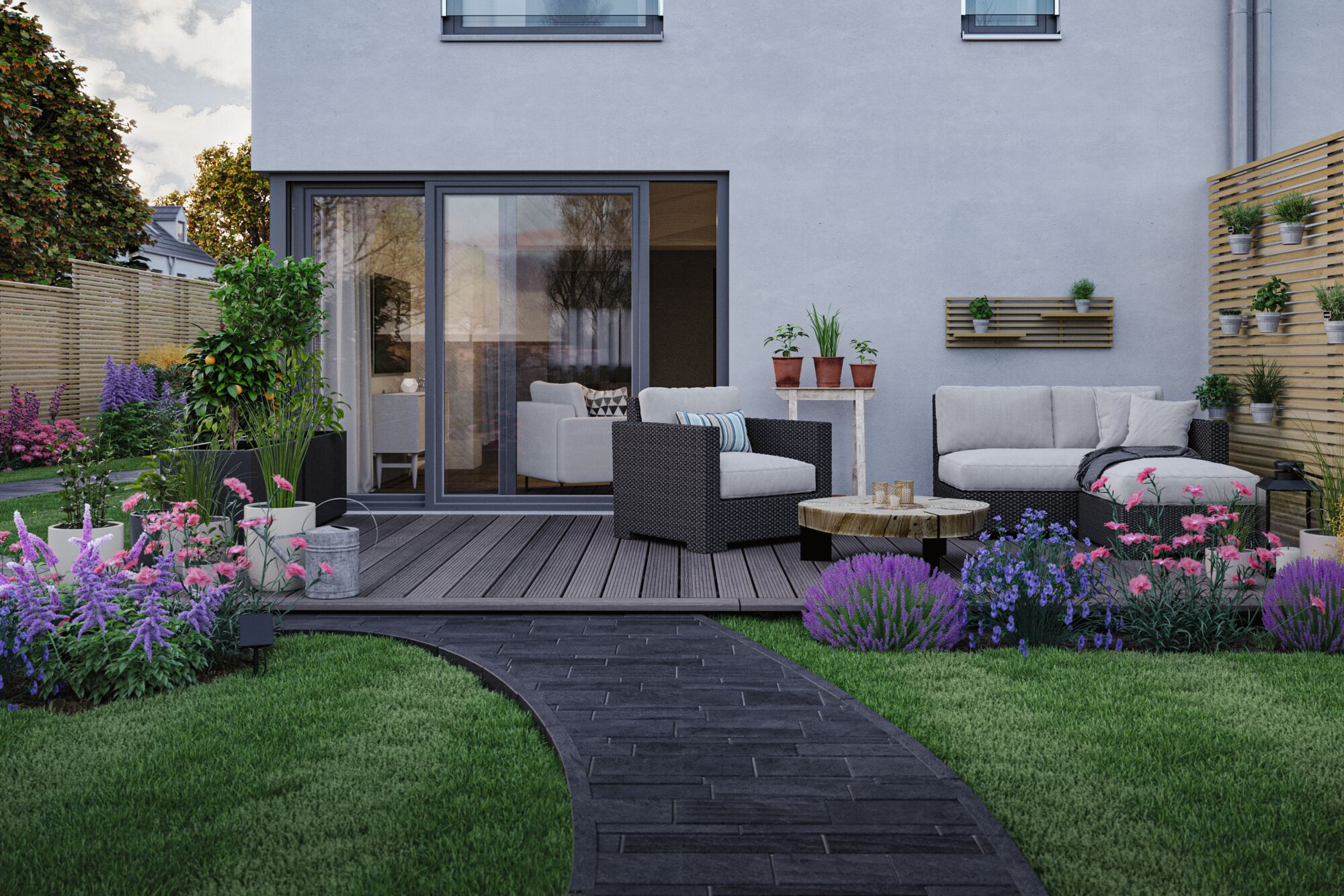 Moderne Terrasse mit Möbeln, Pflanzen und gepflastertem Weg vor einer weißen Hauswand.