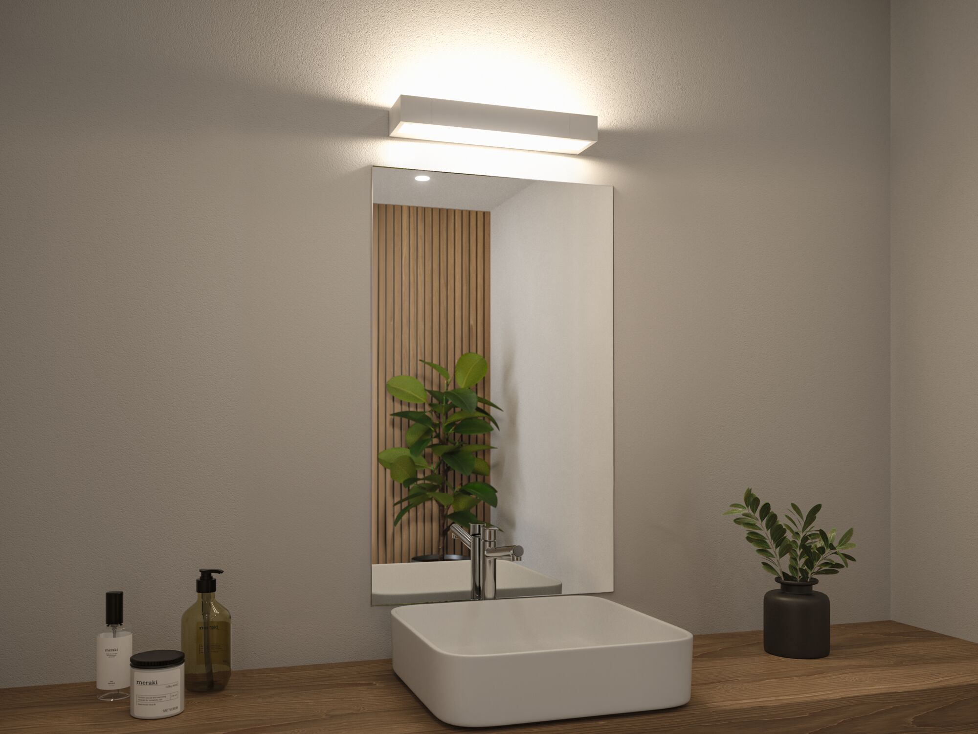 Badezimmer mit weißem Waschbecken, Spiegel, Leuchte und Holztheke mit Pflanzen.