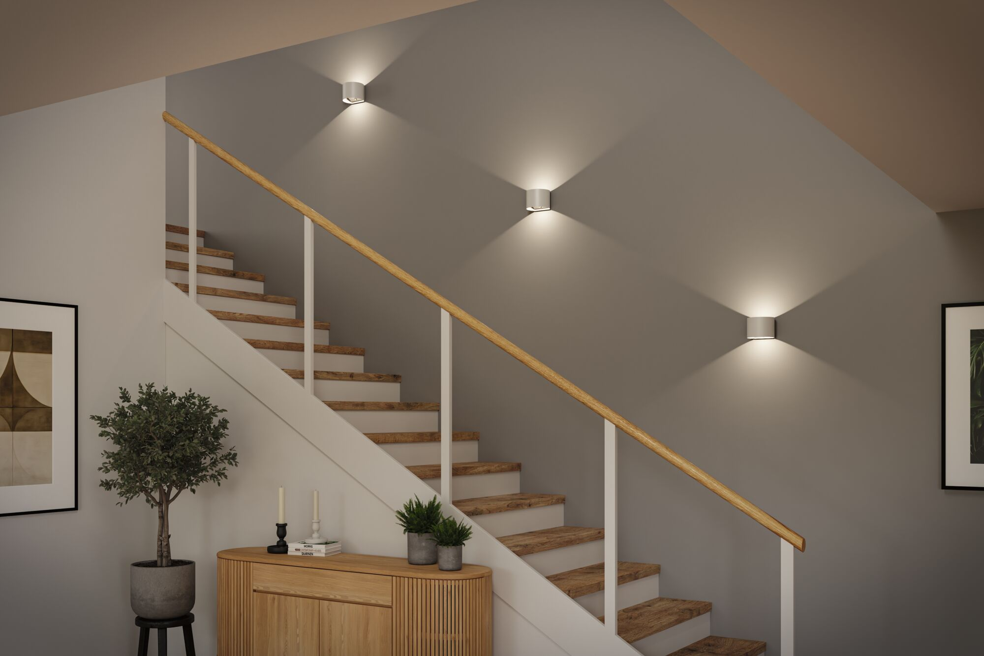 Moderne Treppe mit Holzstufen, weißem Geländer und drei runden Wandleuchten an der grauen Wand.