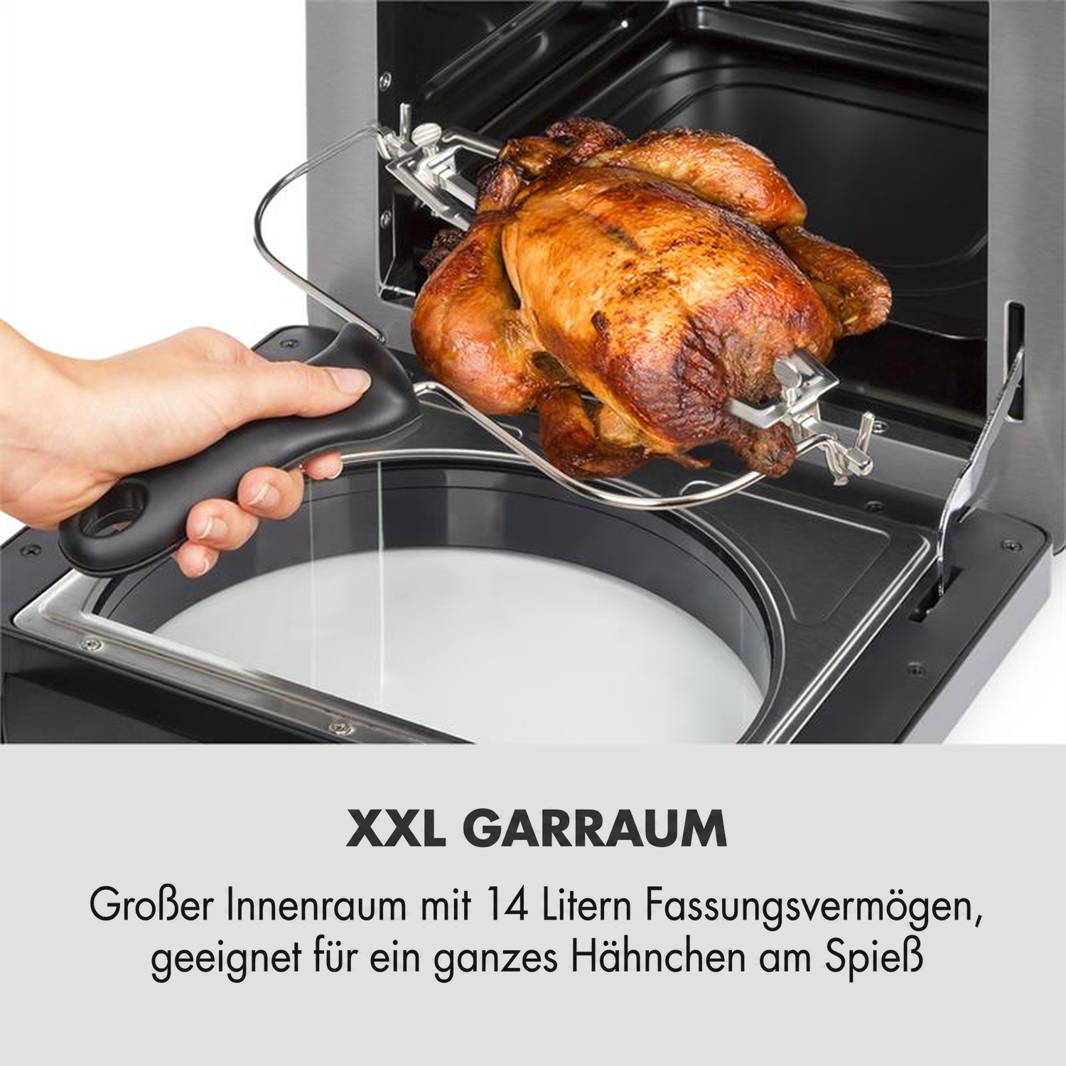 Ein Hähnchen wird mit einem Griff aus dem XXL-Ofen genommen.