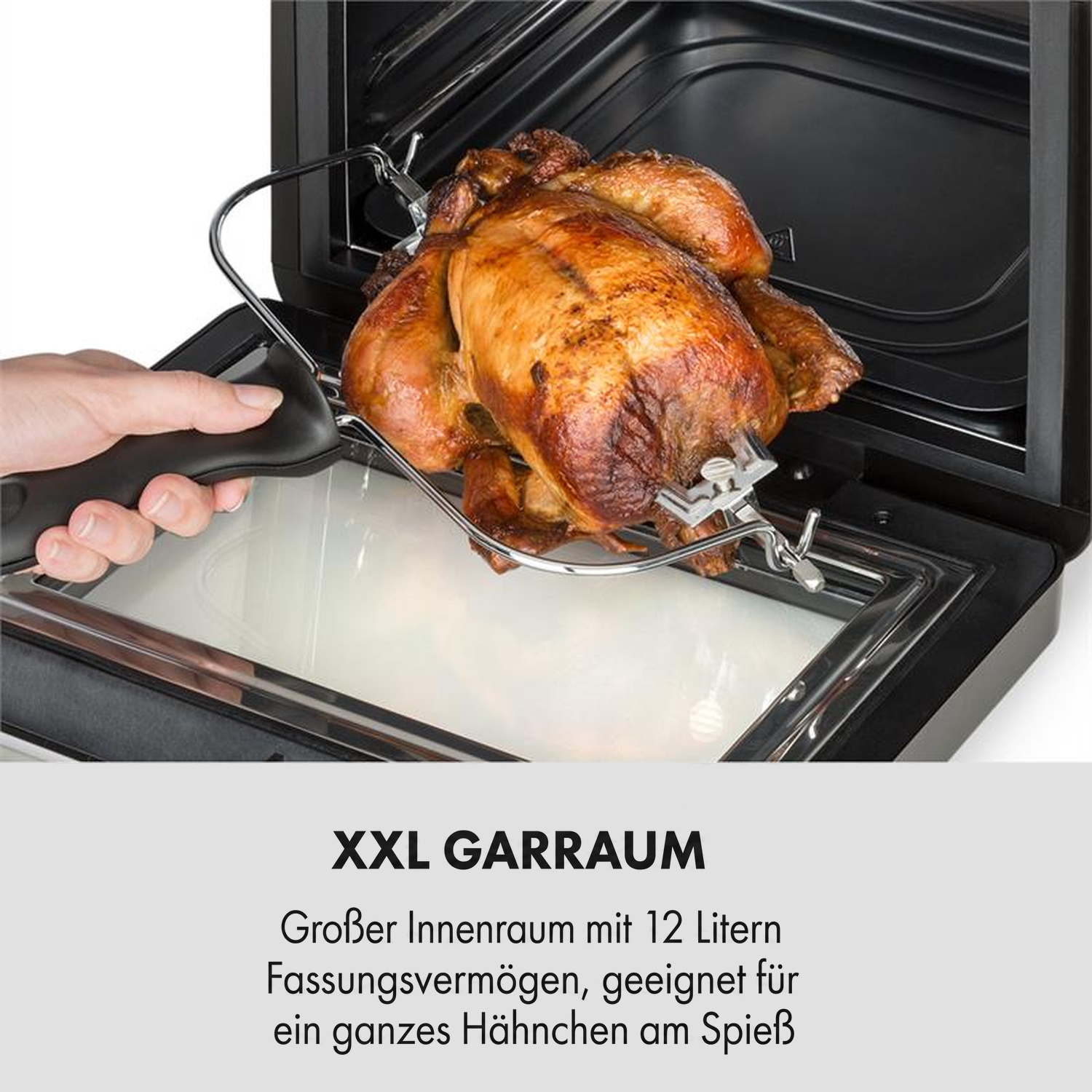 Ein ganzes Hähnchen auf einem Spieß wird in einen großen Ofen eingesetzt.