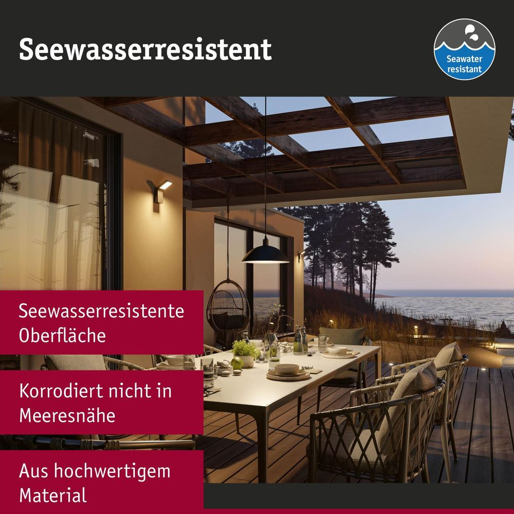 Moderne Außenleuchten an einer Terrasse am Meer mit Esstisch und Stühlen bei Sonnenuntergang.