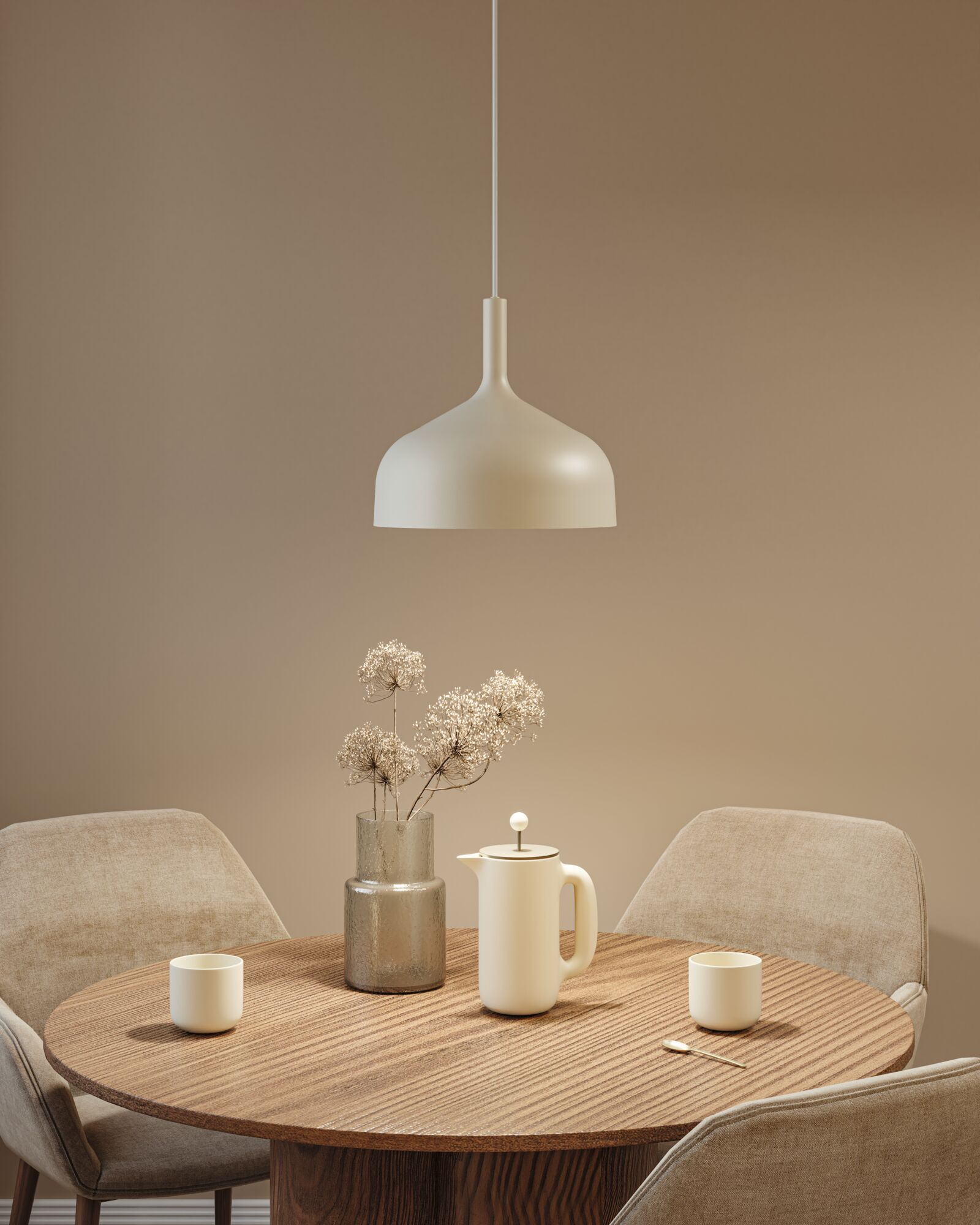 Ein runder Holztisch mit Stühlen, Kaffeekanne, Tassen und einer Glasvase mit Blumen unter einer Pendelleuchte.