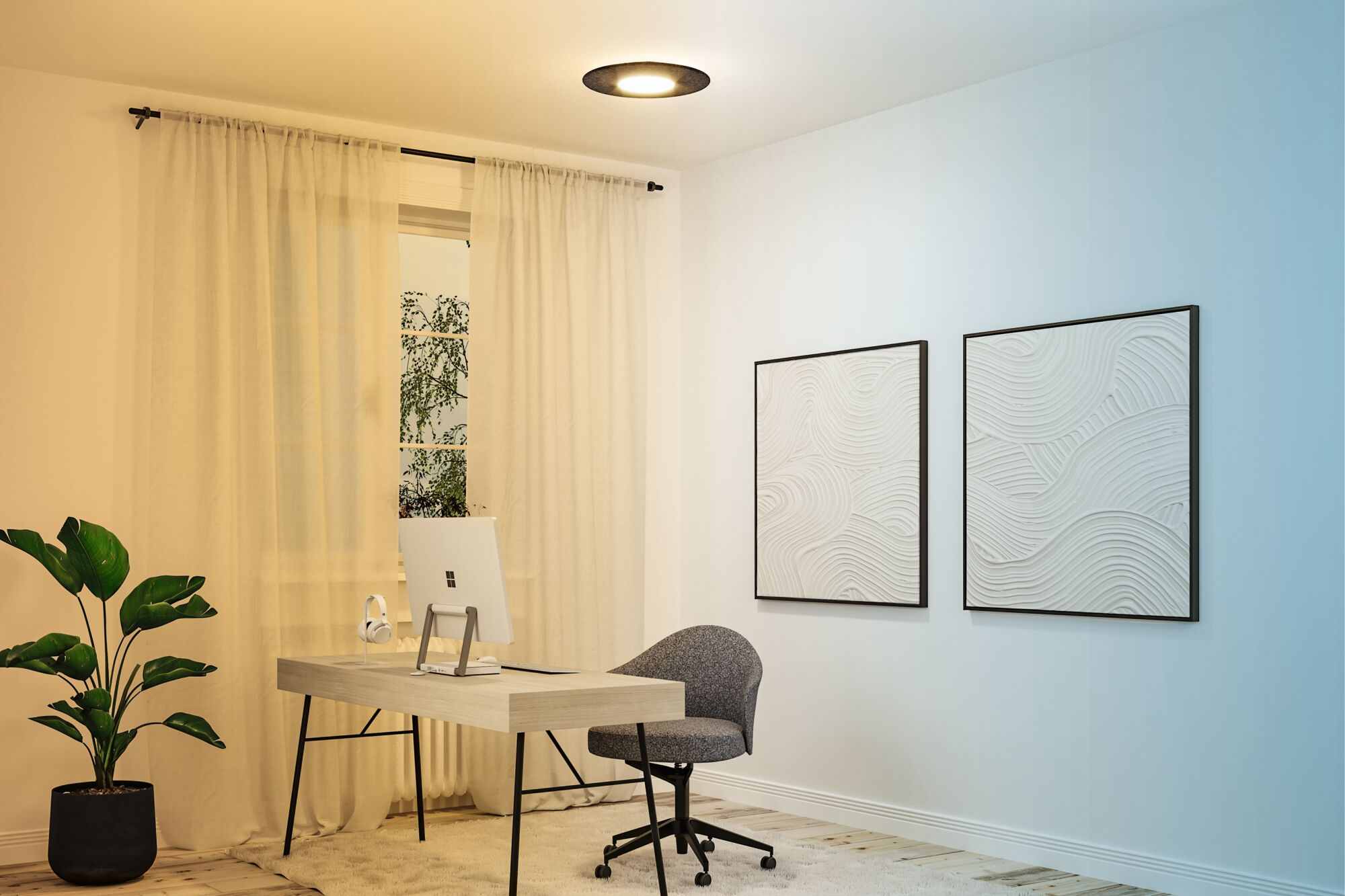 Moderne Arbeitszimmer mit Schreibtisch, grauem Stuhl, Computer und zwei Wandgemälden unter warmem und kühlem Licht.