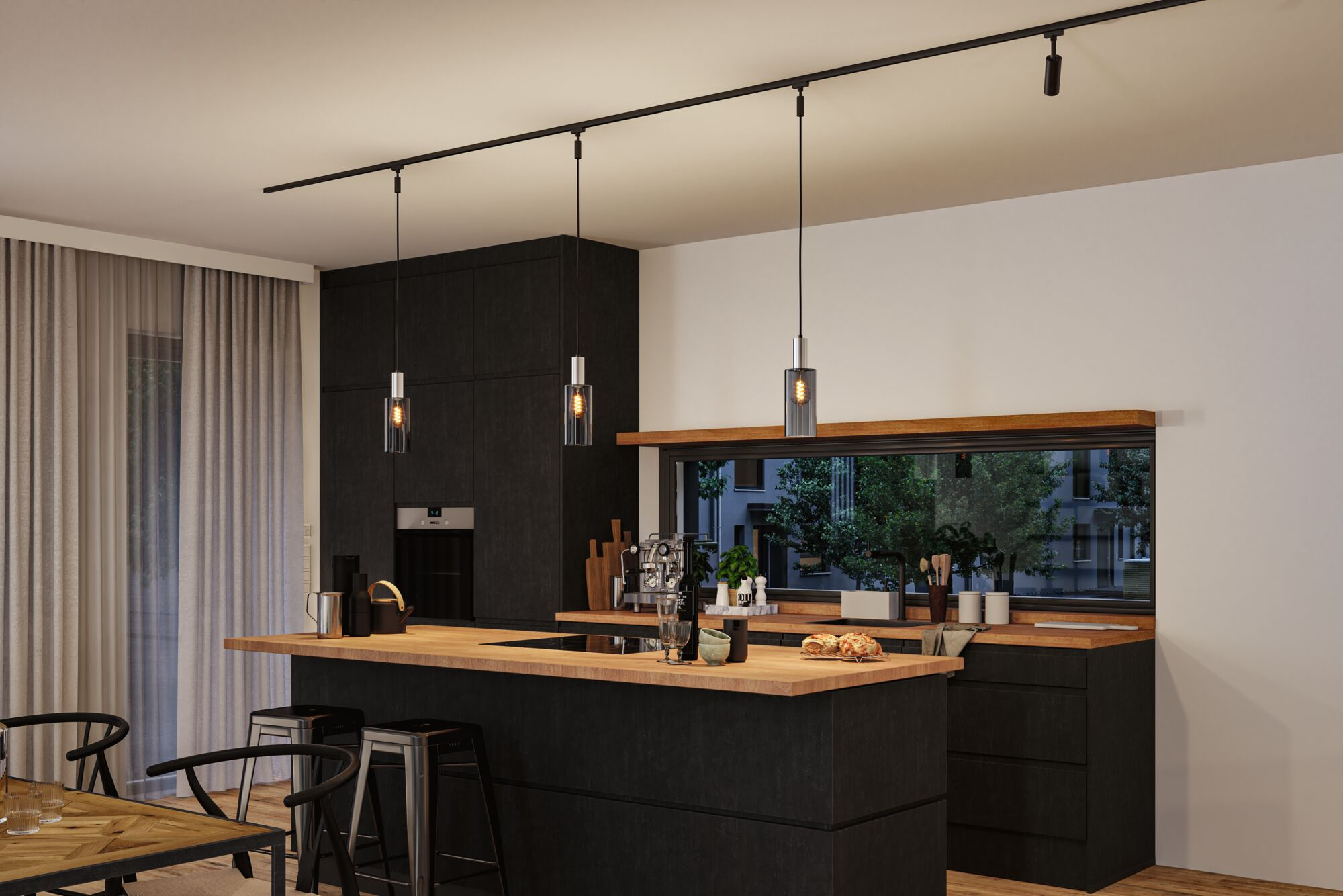 Moderne schwarze Küche mit Holzinsel, drei Pendelleuchten und Blick auf grüne Bäume durch ein langes Fenster.
