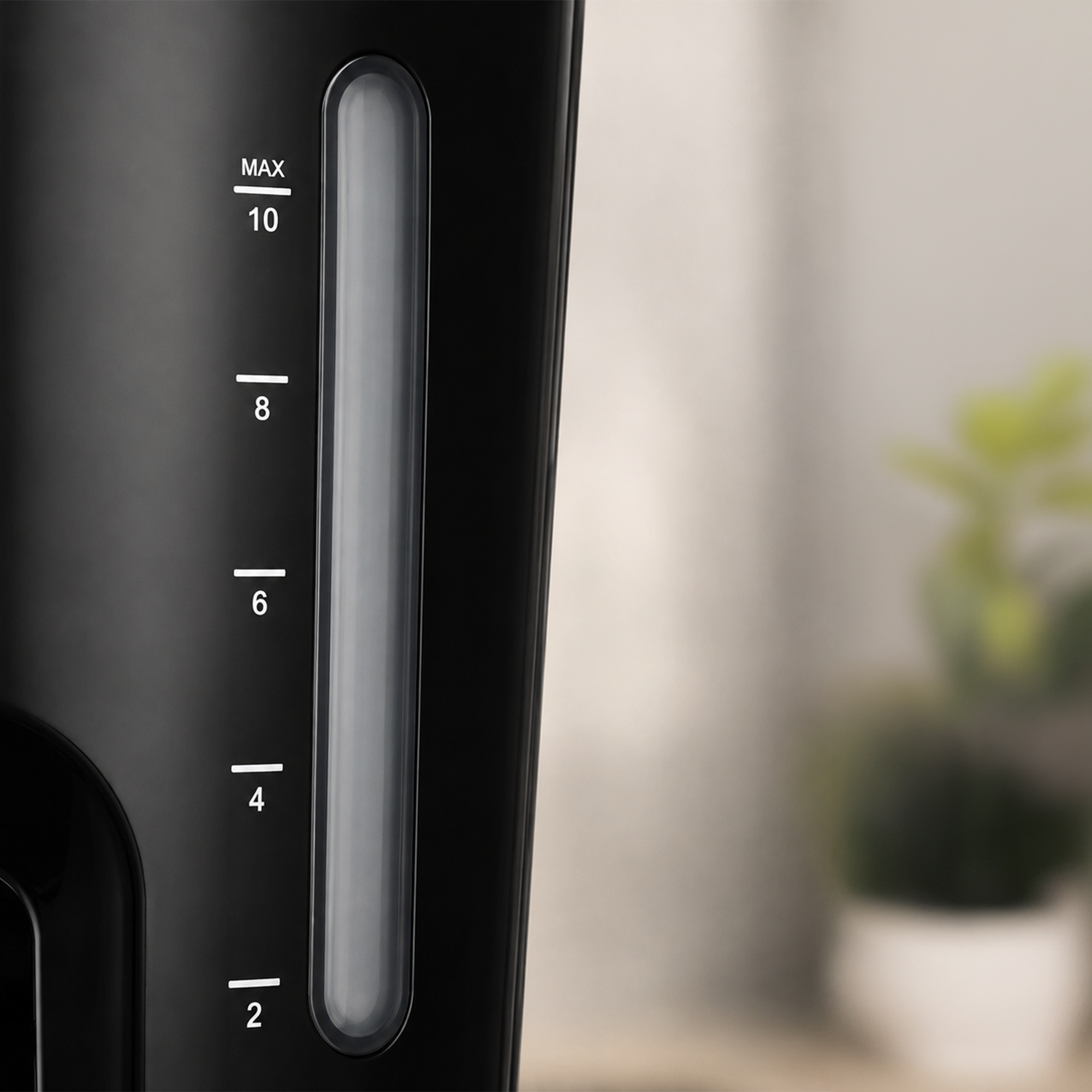 Gros plan sur une cafetière noire avec un indicateur de niveau d'eau de 2 à 10 tasses.